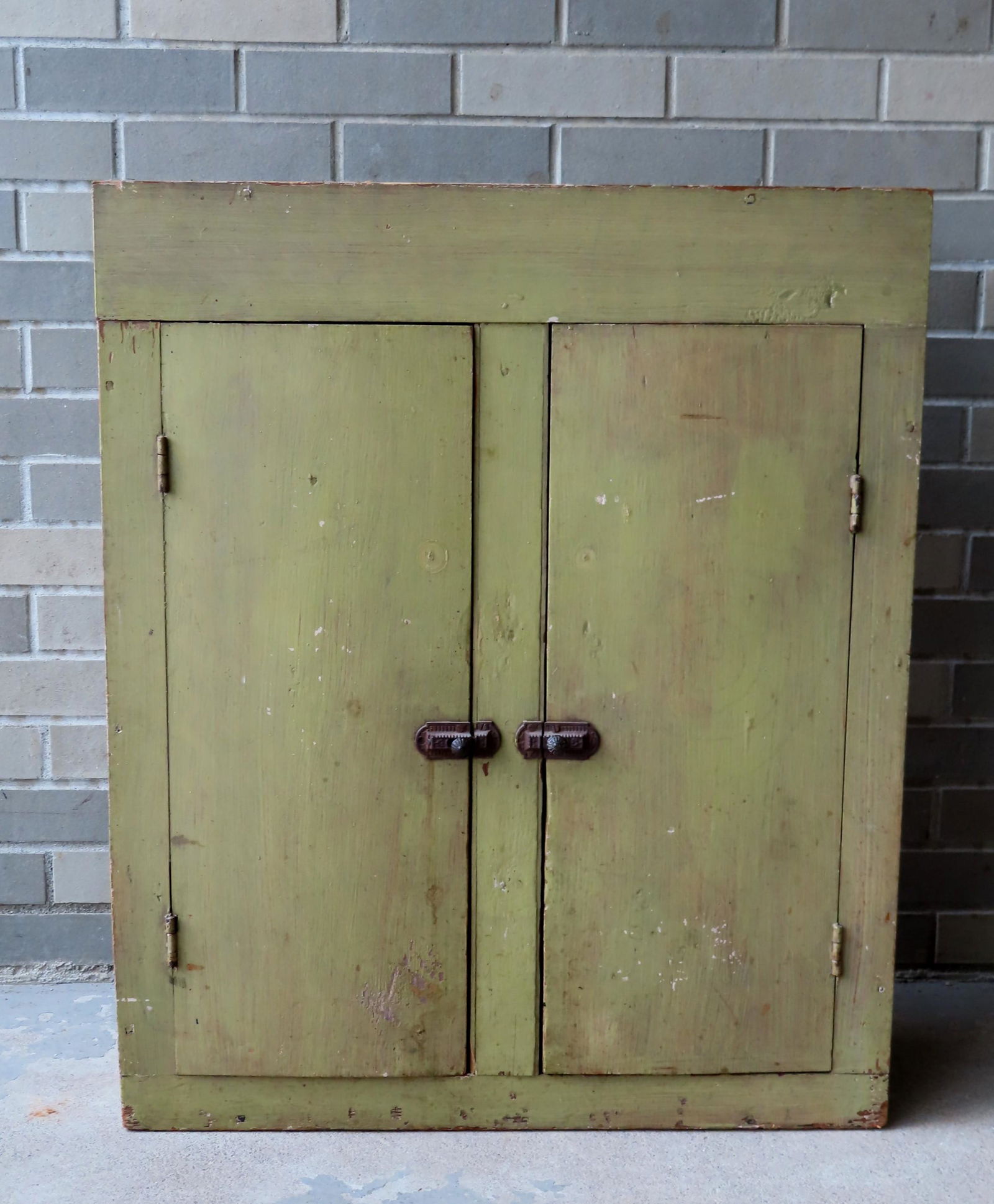 A small 2 door cupboard in an old ochre colored paint, (1 of 7)
