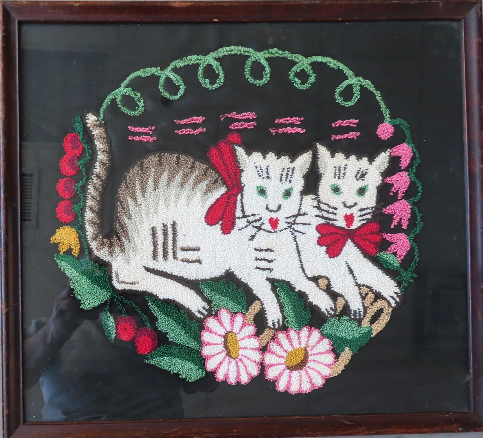A framed embroidered textile featuring 2 resting cats (1 of 2)