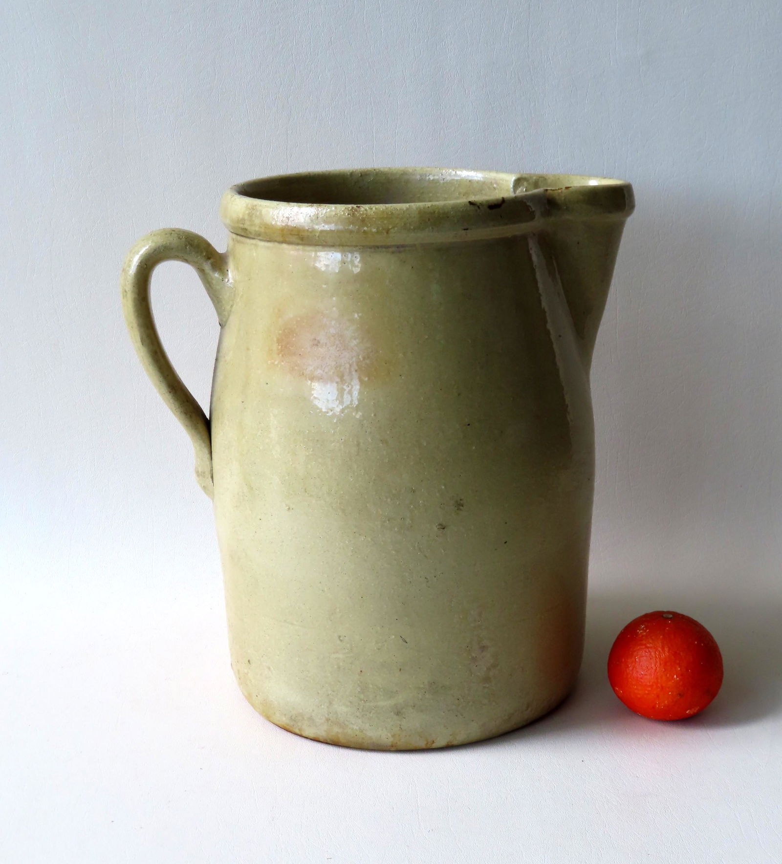 An unusually large stoneware pitcher with yellow glaze, (1 of 4)