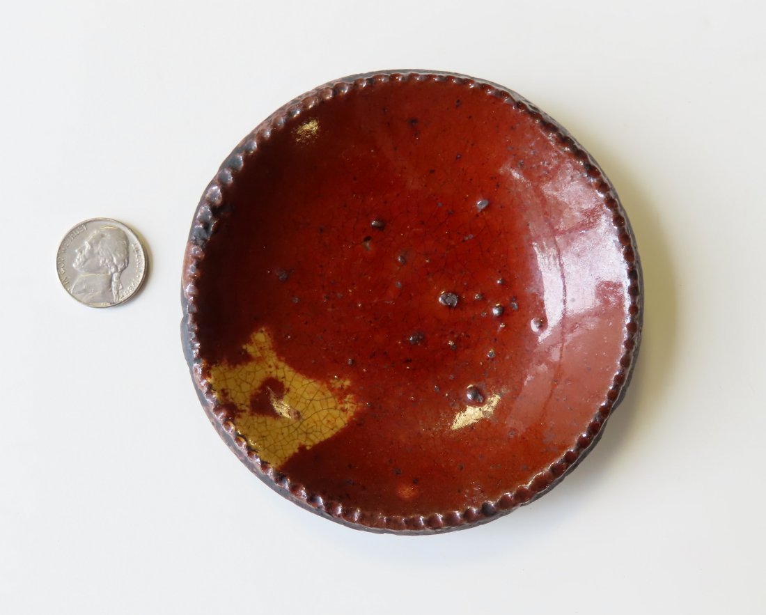A miniature redware plate with yellow slip decoration (1 of 5)