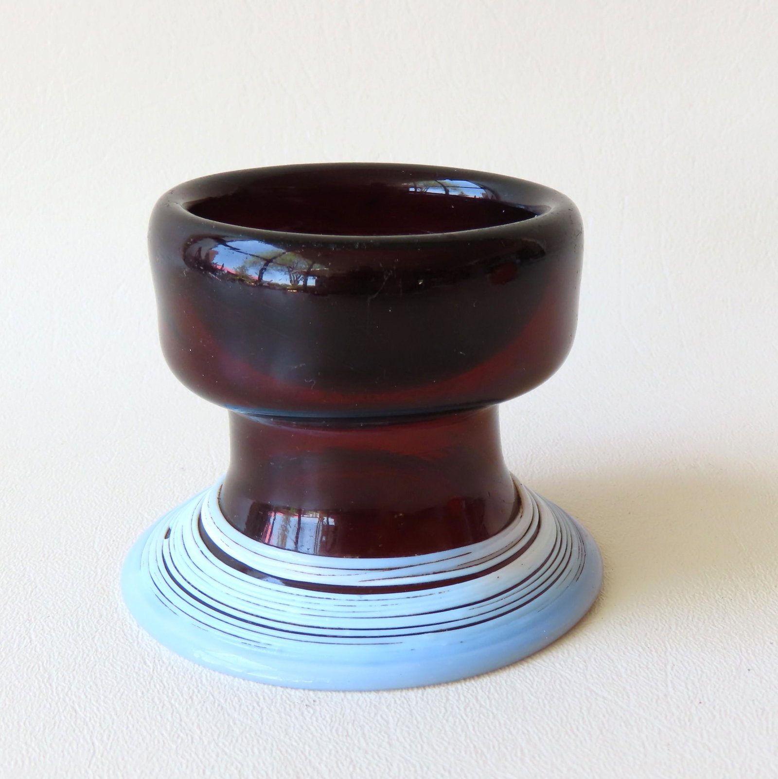 An unusual piece of early dark amber glass that appears: An unusual piece of early dark amber glass that appears to double as a salt cellar and lady's spittoon. The top section, the spittoon with white threaded flared mouth, and the bottom section, when rev