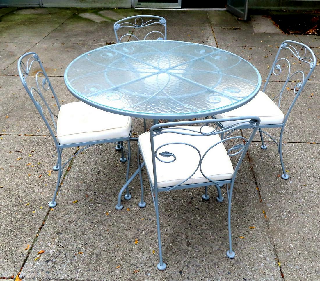 Meadowcraft wrought iron patio set in leaf and vine: Meadowcraft wrought iron patio set in leaf and vine pattern in original blue paint. The set includes a round glass top table 42 1/2" diameter x 28 1/2"H, and 4 chairs with original seat cushions signe