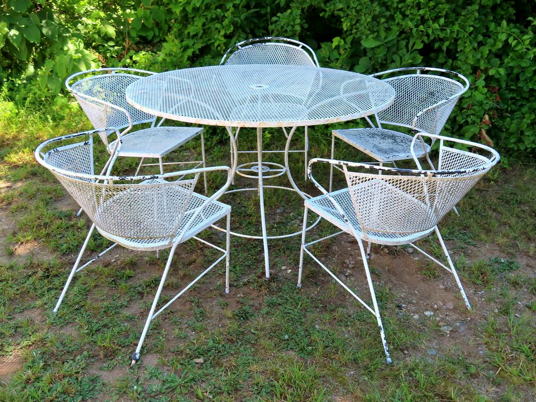 A wire mesh patio set consisting of a round table: A wire mesh patio set consisting of a round table measuring 48" diameter x 29"H, and 5 chairs with curved backs - slight surface rust and overall good condition.