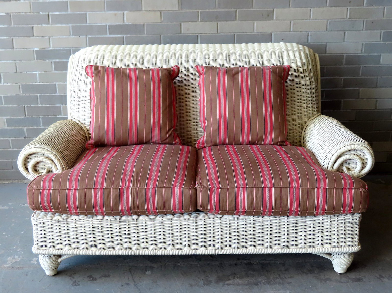 A Ralph Lauren high quality wicker porch set consisting: A Ralph Lauren high quality wicker porch set consisting of a couch, chair and ottoman. All purchased circa 2000 and in very good, clean condition, including cushions. The couch measures 61"W x 44"D x