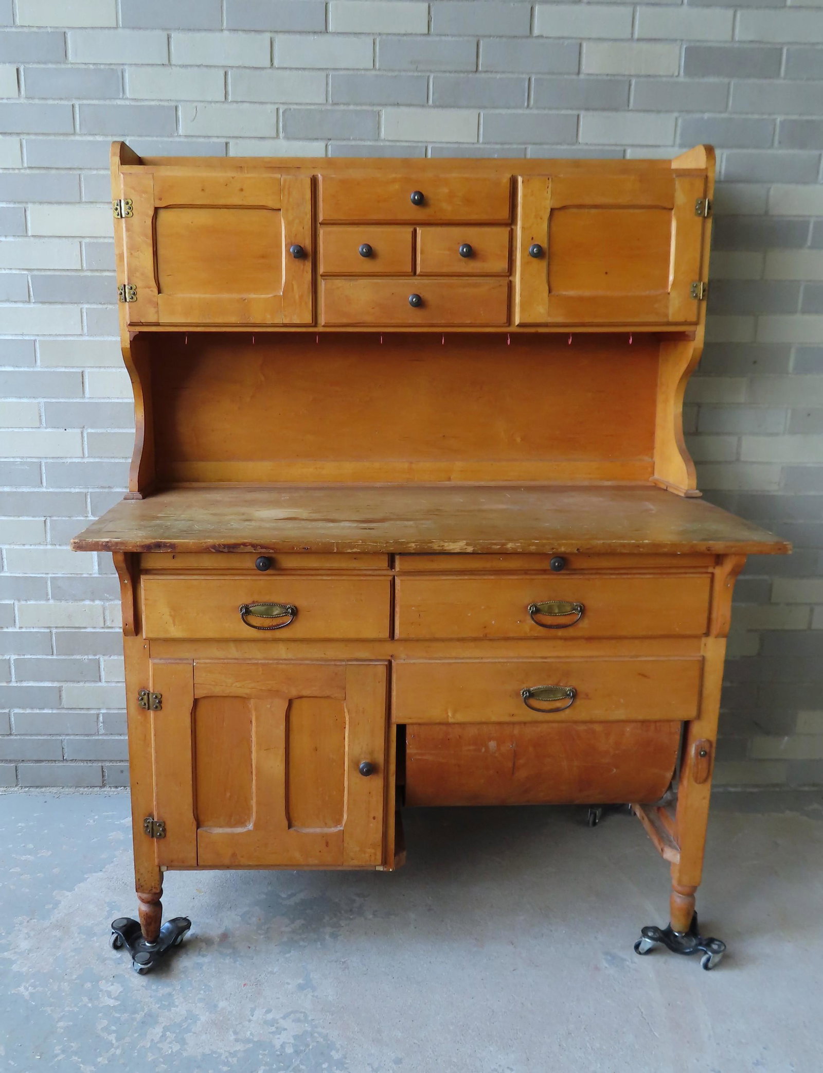 Vintage maple baker's 2 part cupboard, having a top: Vintage maple baker's 2 part cupboard, having a top section with 4 center drawers flanked by 2 doors over open shelf over 2 pullout breadboards over 2 long drawers over single door cupboard on right a