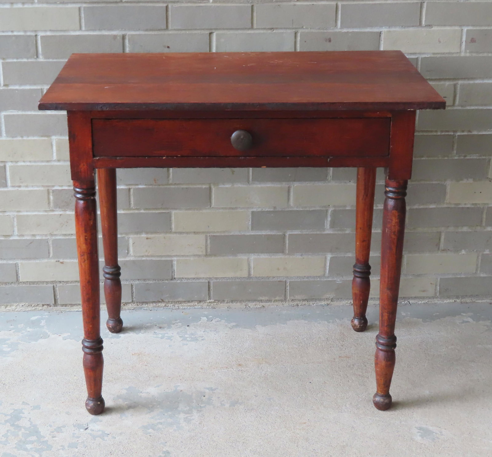 A Sheraton work table with turned legs, center drawer,: A Sheraton work table with turned legs, center drawer, early to mid 19th century, poplar wood construction with traces of original red stain. Good structural condition. 31 1/4"W x 20 1/4"D x 28 3/4"H.