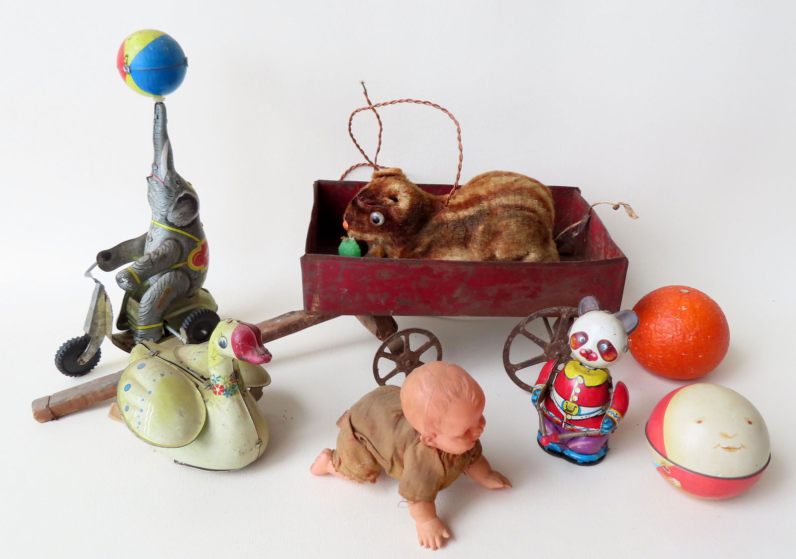 Grouping of old toys.: Grouping of old toys, including 1 late 19th century doll-size tin pull wagon with traces of original red paint - 18" total length x 6'w x 4 3/4"H - fair condition; a lithographed tin windup elephant o