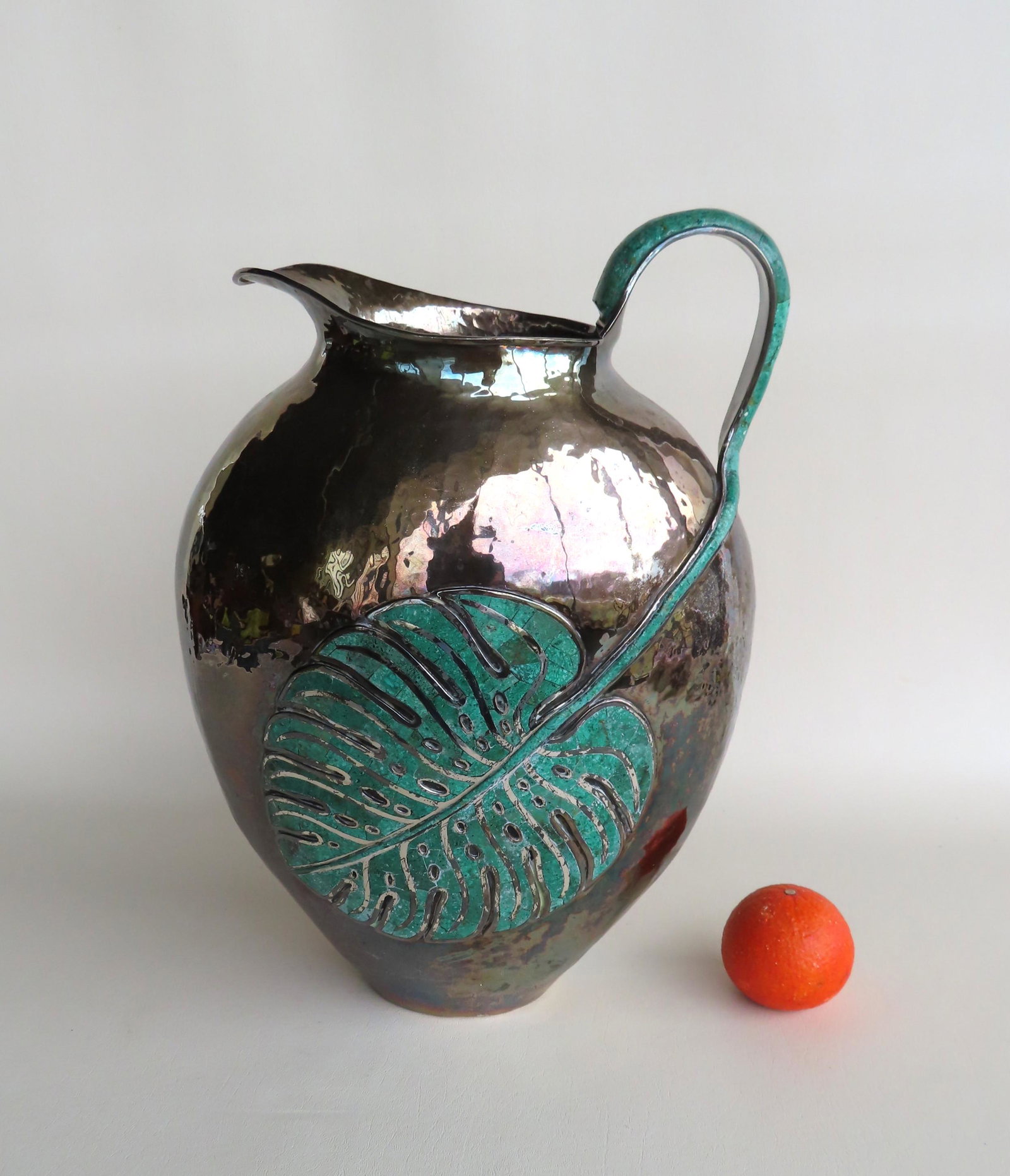 An Emilia Castillo mid century style hand hammered: An Emilia Castillo mid century style hand hammered silver-plate & copper pitcher with large malachite inlaid leaf extending from handle to body. Signed on base "Plateado / Emilia Castillo / Mexico M.R
