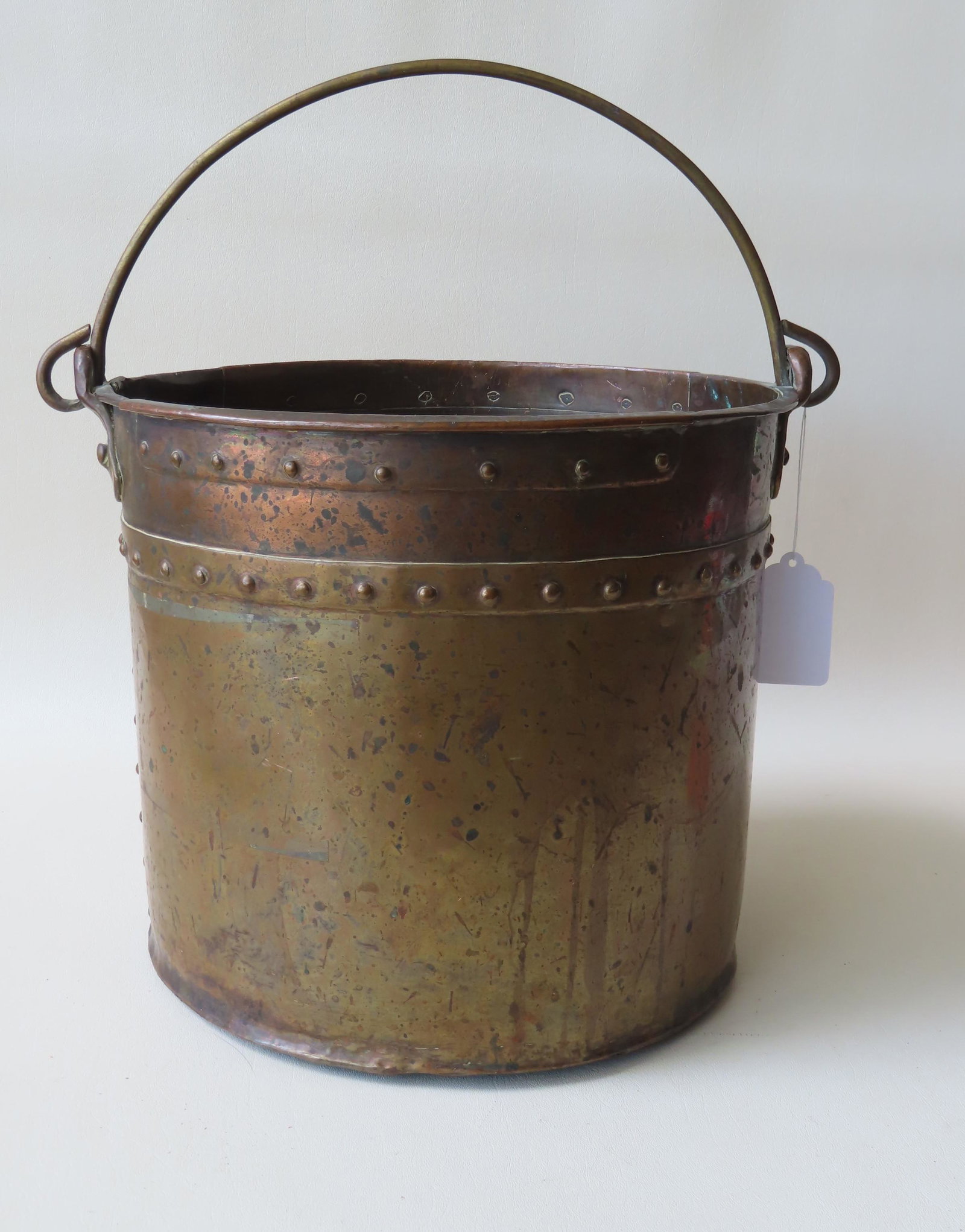 An early heavy duty copper bucket with swivel handle,: An early heavy duty copper bucket with swivel handle, hand made, and original applied copper straps with rivets added for extra strength, 19th century. Arts and crafts style. 12 1/2"H x 16"W. Expected