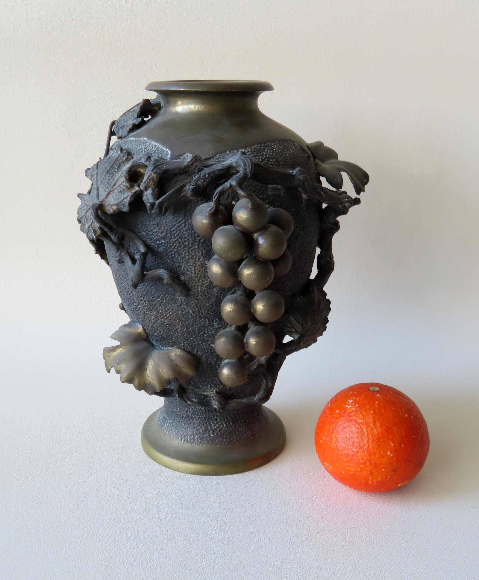 A Japanese bronze vase decorated with applied grapes: A Japanese bronze vase decorated with applied grapes and leaves on vines, traces of original gilding, probably Meiji period late 19th to early 20th century. Very good condition. 10 1/2"H x 8"W. Unknow