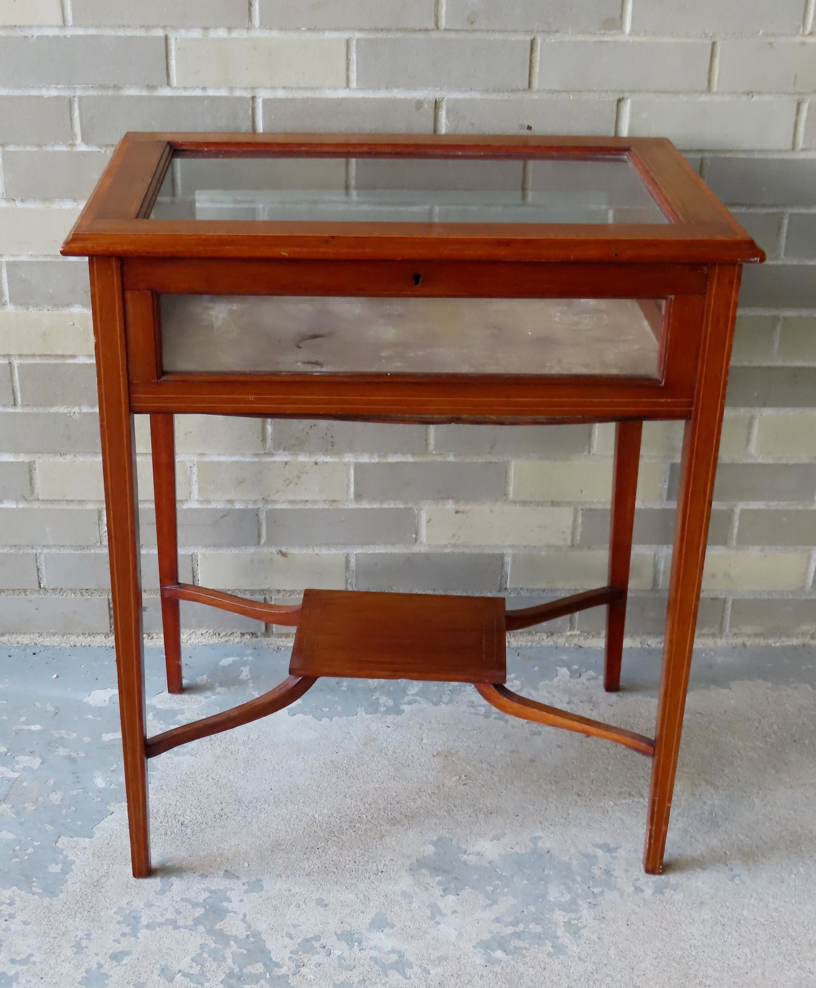 Floor standing Hepplewhite style display case with lift: Floor standing Hepplewhite style display case with lift top, lower shelf, molded edge, banded inlay around lid, and pin-striping on legs, late 19th century. Very good condition. 25"W x 16 1/2"D x 29 1