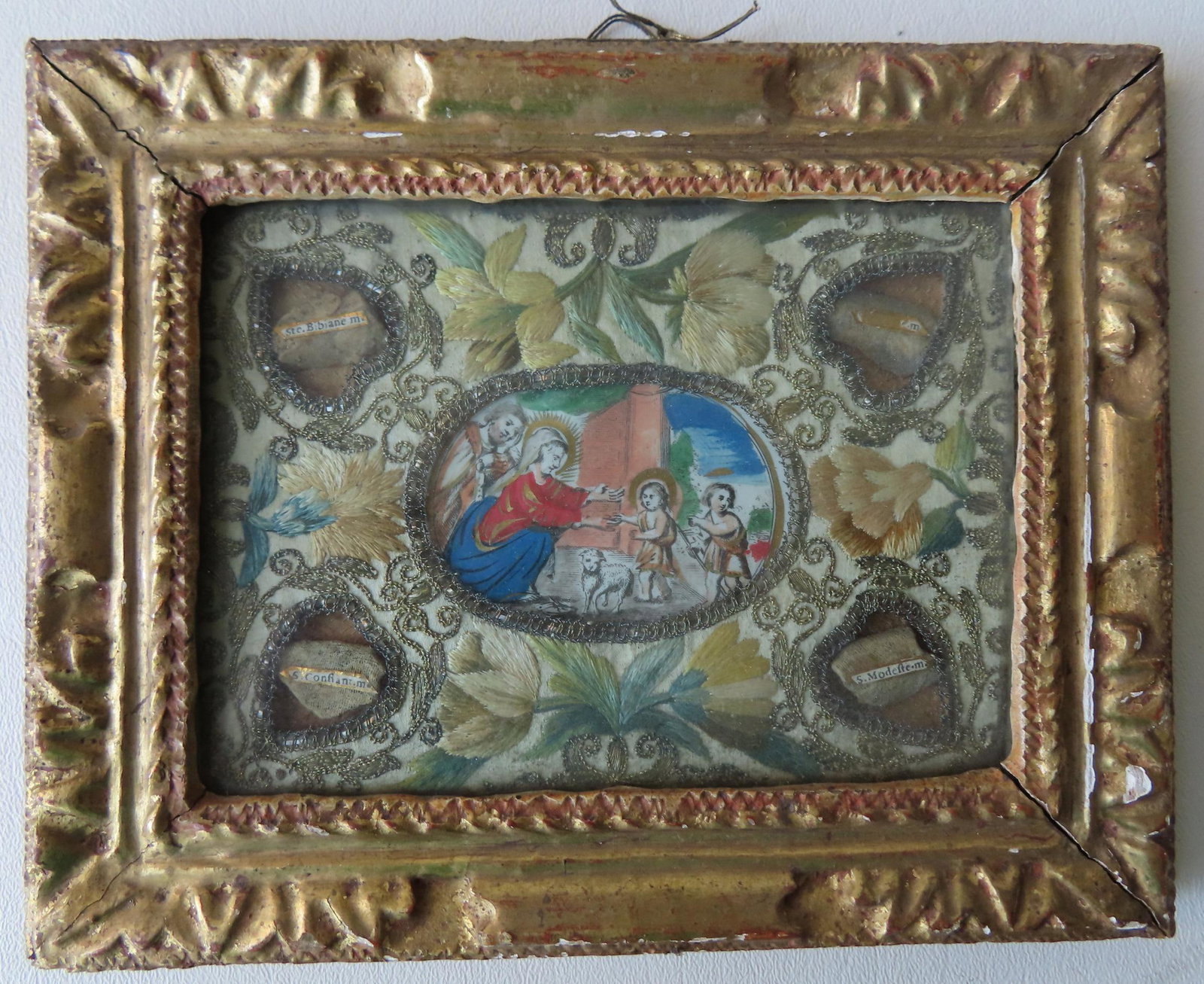 Small religious silk embroidery having ancient saint: Small religious silk embroidery having ancient saint relics applied in all 4 corners surrounded by embroidered hearts, each saint being identified - the embroidery work encircles an original 18th cent