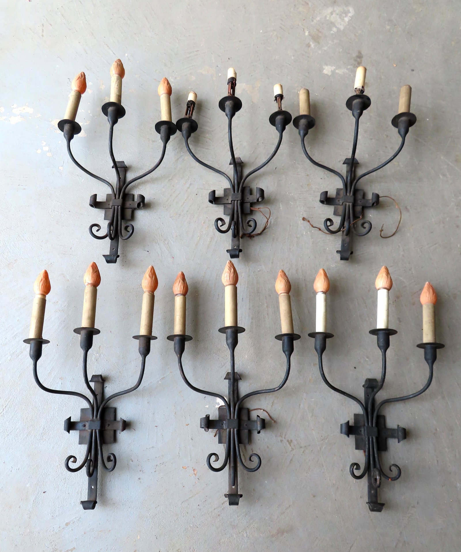 A set of 6 matching wrought iron gothic style: A set of 6 matching wrought iron gothic style electrified 3 light wall sconces, reportedly from a Westchester County NY mansion undergoing restoration, circa 1920. Need to be rewired otherwise in good