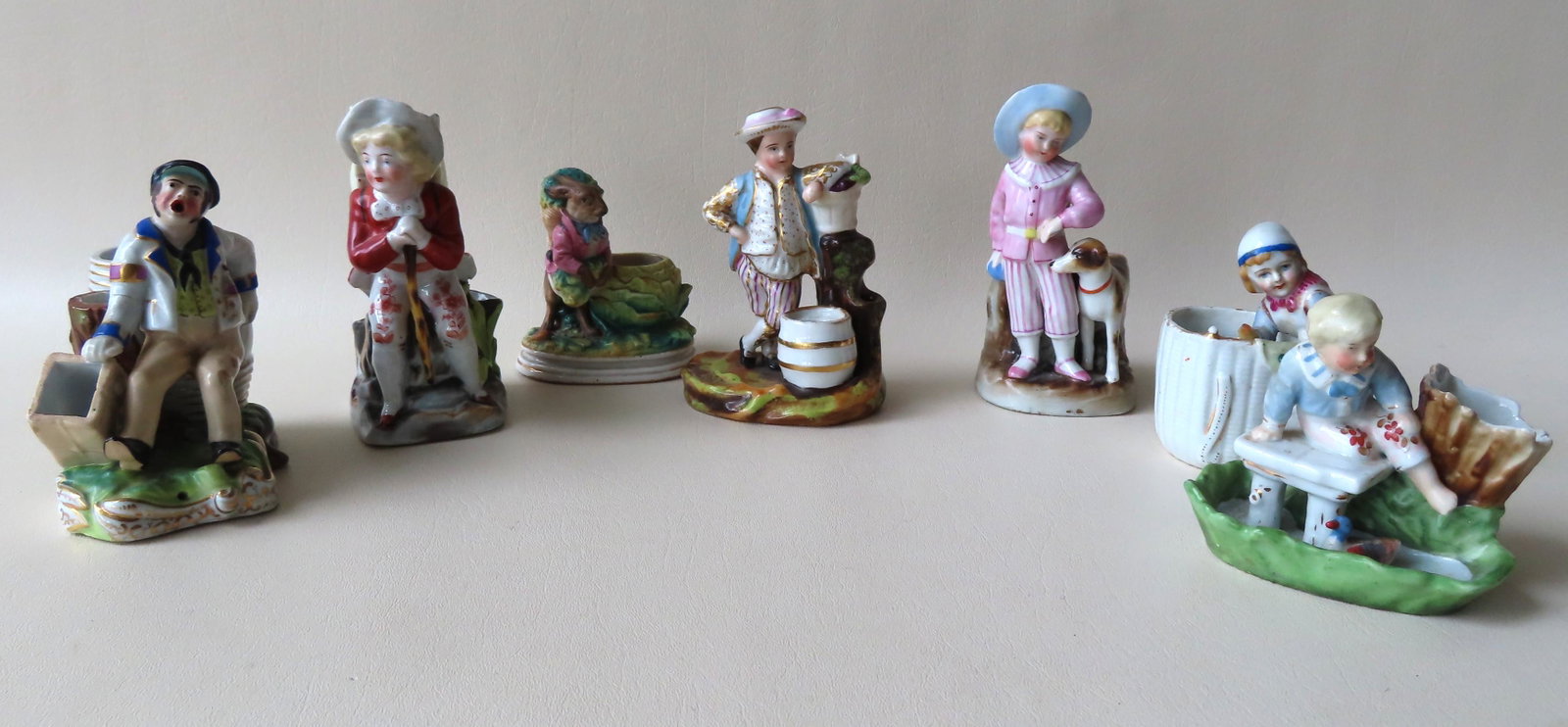 A grouping of 7 German figural porcelain match safes: A grouping of 7 German figural porcelain match safes and toothpick holder, not signed. Including one of a drunken sailor - appears to be a combination tobacco, cigarette, and match safe (note the hole