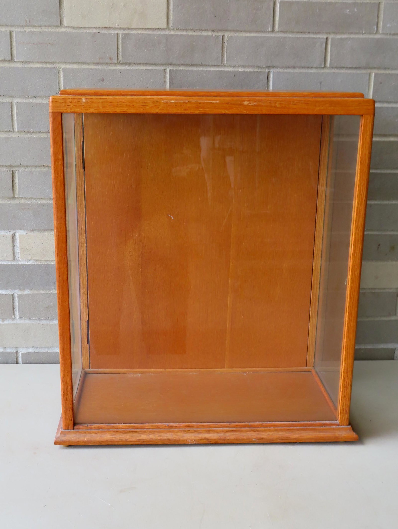 An oak table top display case with glass on 3 sides and: An oak table top display case with glass on 3 sides and rear door. Can be used for a ship model or taxidermy. Early 20th century. Very good condition. Measures 19 3/4"W x 10 1/4"D x 23 3/4"H.