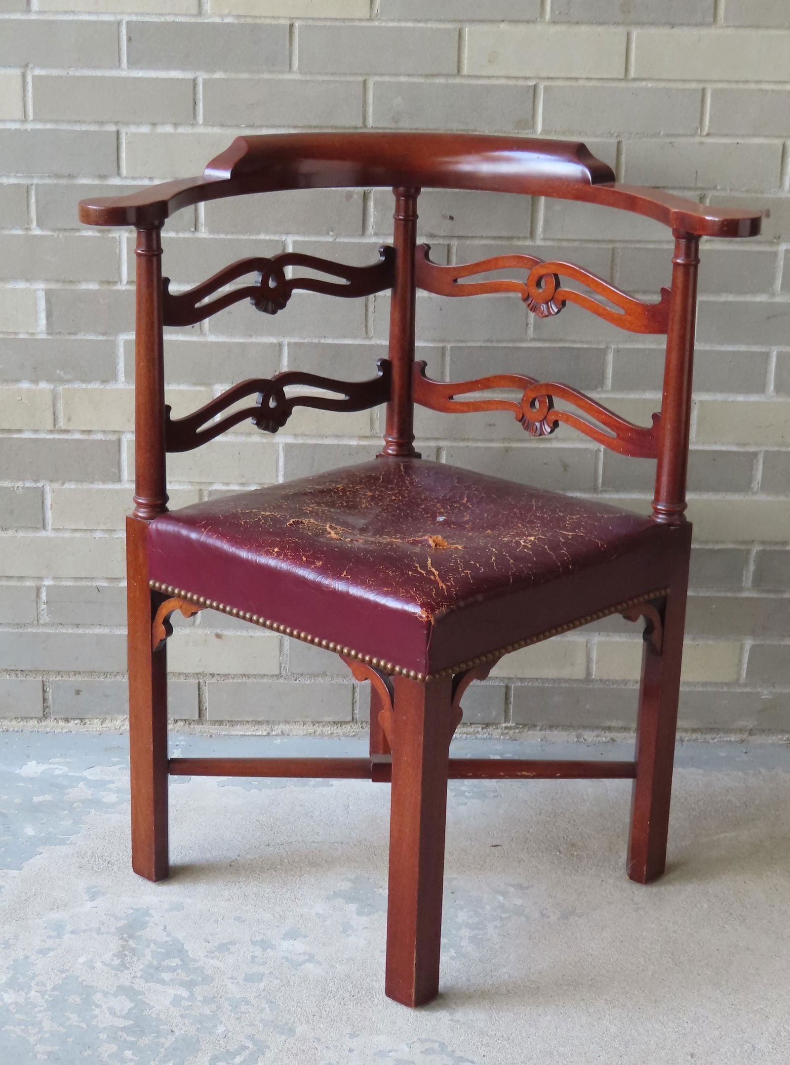 a Chippendale style ribbon back mahogany corner chair: a Chippendale style ribbon back mahogany corner chair with cross stretchers and leather seat, early to mid 20th century - some wear to leather otherwise very good condition.