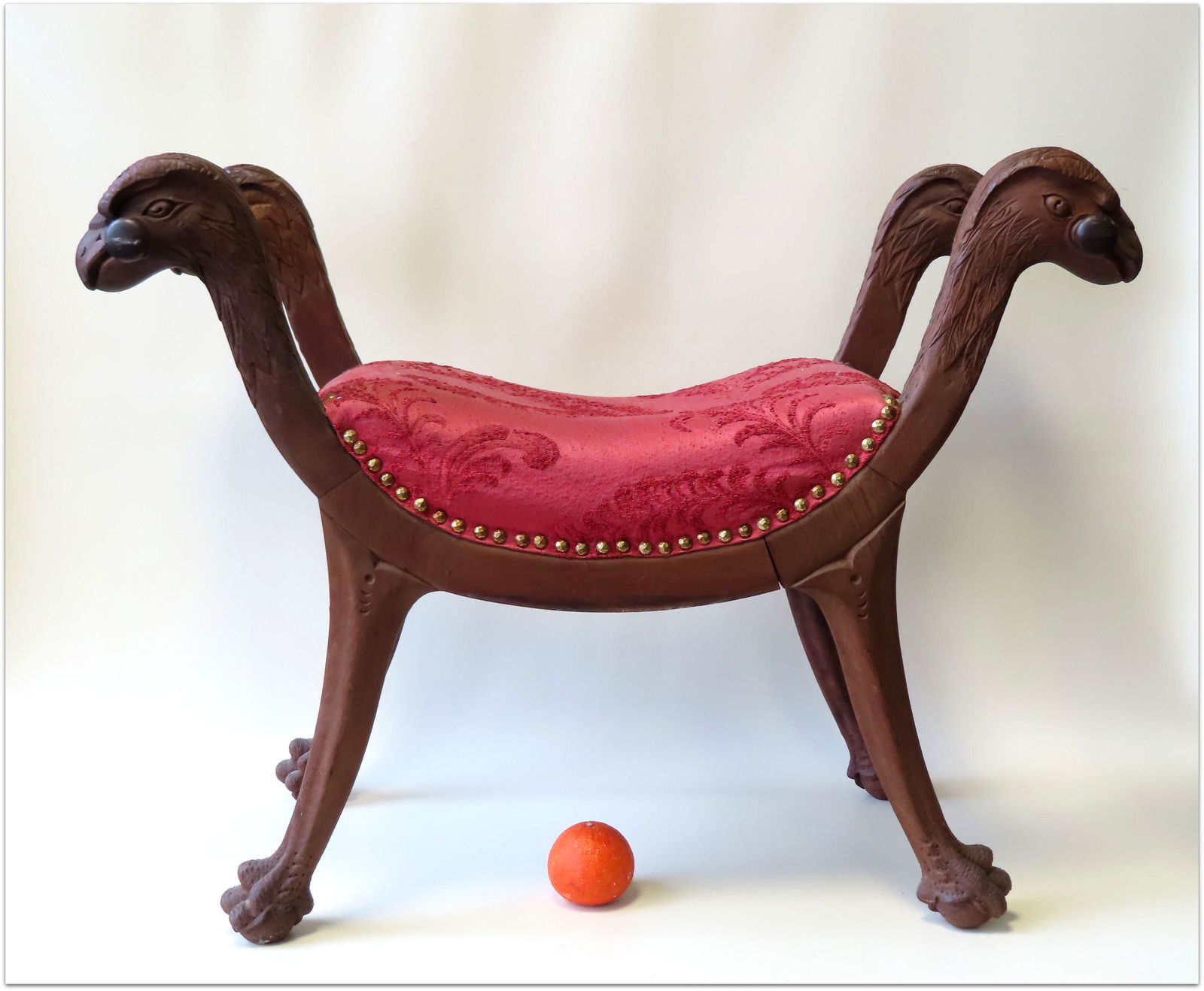 A window bench with carved eagle head terminals in: A window bench with carved eagle head terminals in front and back of both sides leading to lion's paw feet, all in black walnut, circa 1870's. Newer upholstered seat and in very good condition. Measur