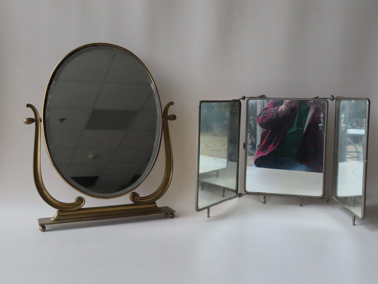 Two lady's vanity mirrors including: A 3 section: Two lady's vanity mirrors including: A 3 section folding mirror with metal frame and celluloid backing decorated with embossed flowers - size in closed position 11"W x 12 3/4"H - very good condition, 