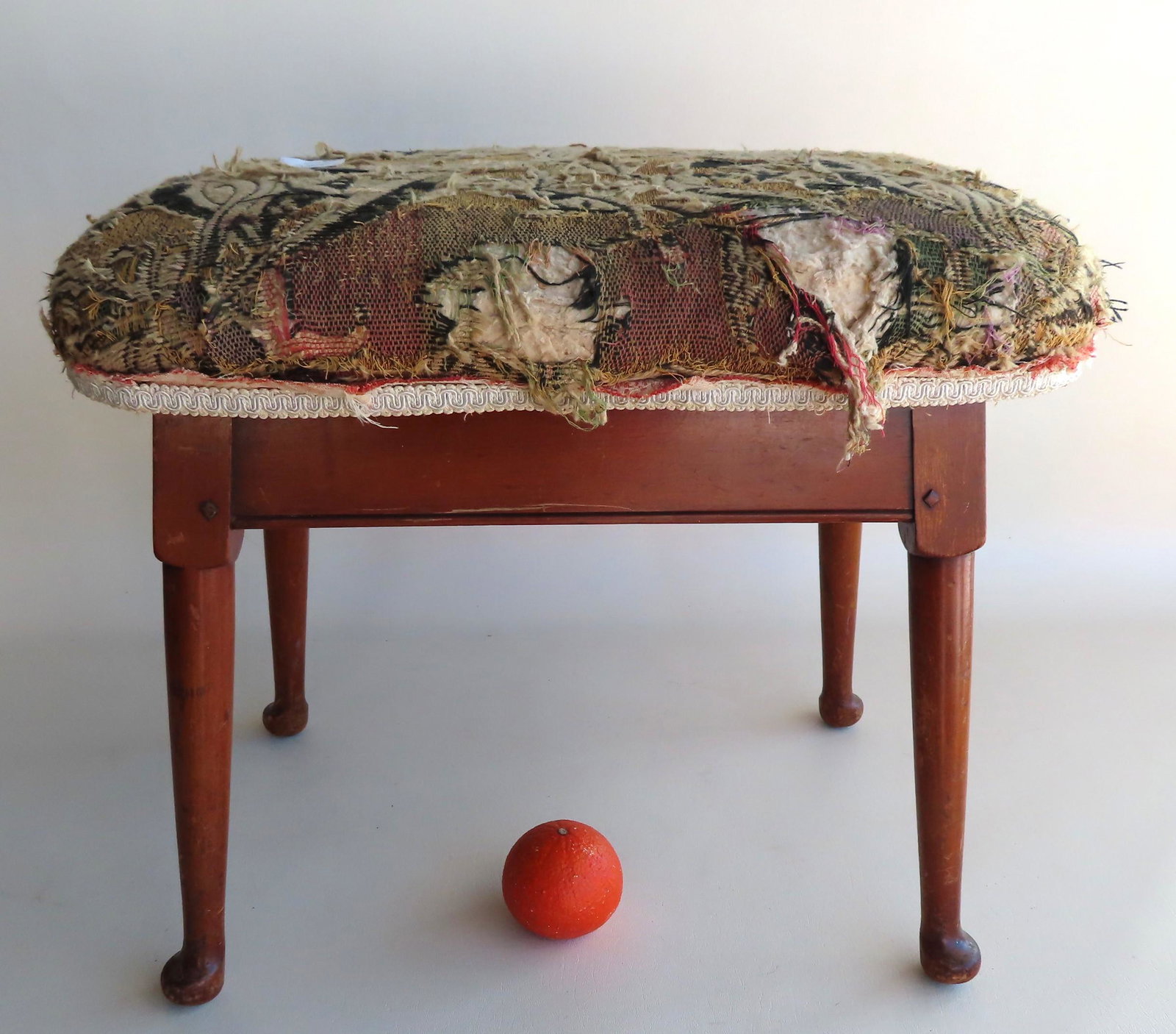 A Queen Ann style maple foot stool with splayed legs,: A Queen Ann style maple foot stool with splayed legs, circa 1920-40. Surface scratches, wear and losses to the fabric top, but good overall condition. 21"W x 15 1/2"D x 17 1/2"H.