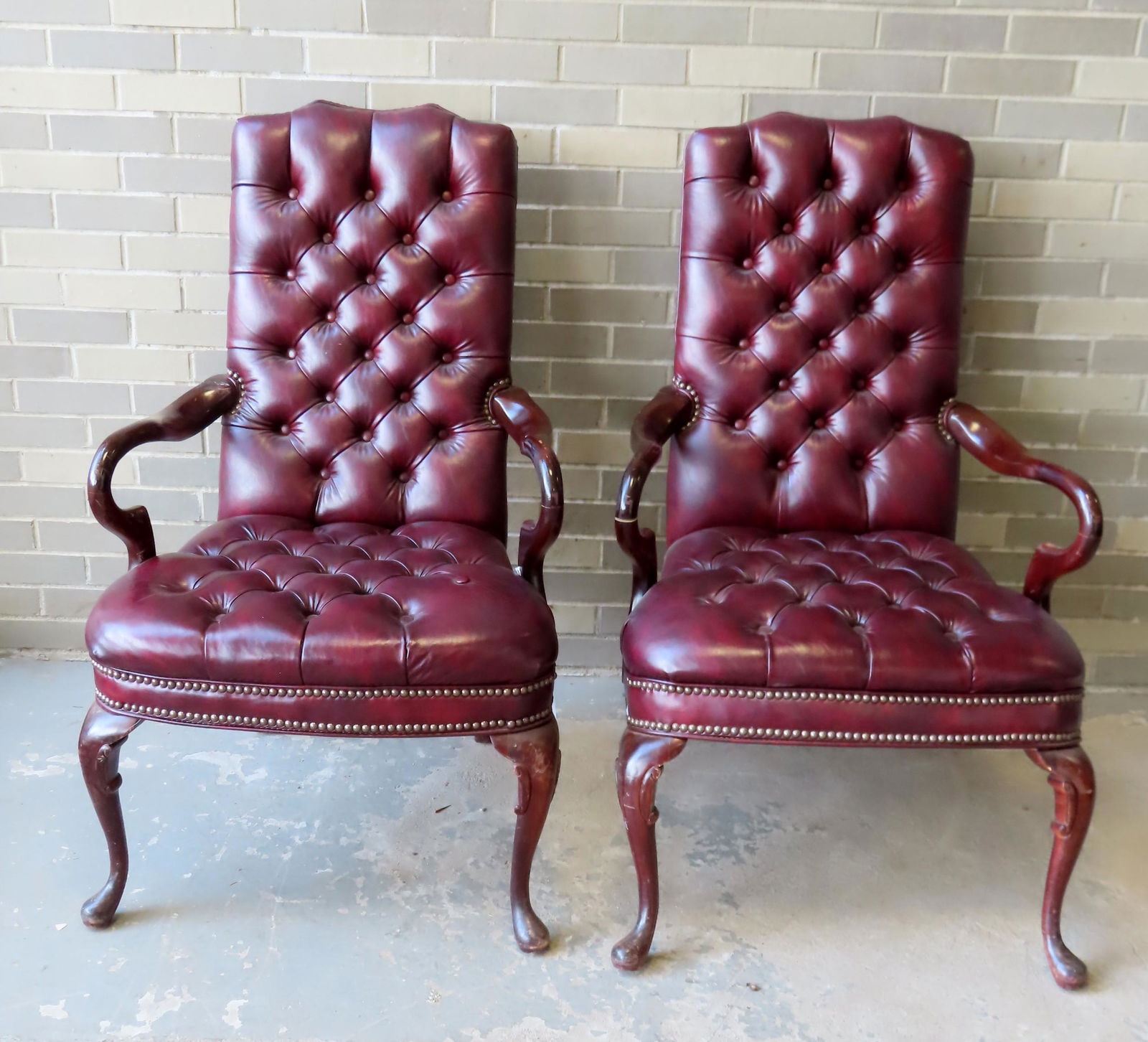Two modern leather parlor chairs with tufted seats and: Two modern leather parlor chairs with tufted seats and back and curved arms in the Queen Ann style. One chair with one popped button, and some surface abrasions to arms and legs, otherwise good condit