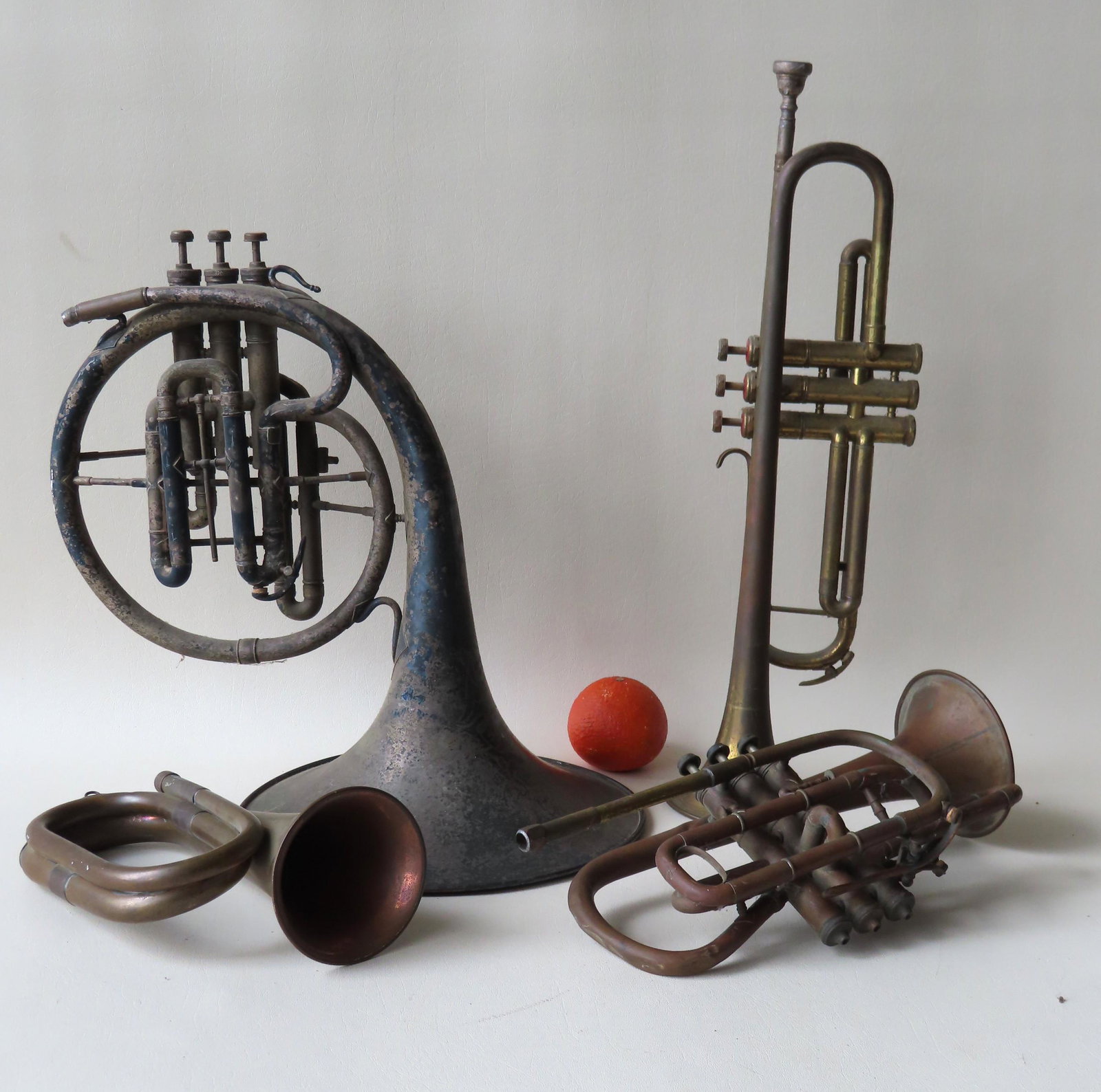 A grouping of 4 vintage horns including an Elkhart: A grouping of 4 vintage horns including an Elkhart French horn, a trumpet marked "Made in Germany", a bass trumpet engraved "New York Wonder Made By C.G. Conn / Elkhart Ind. And New York", and an unma