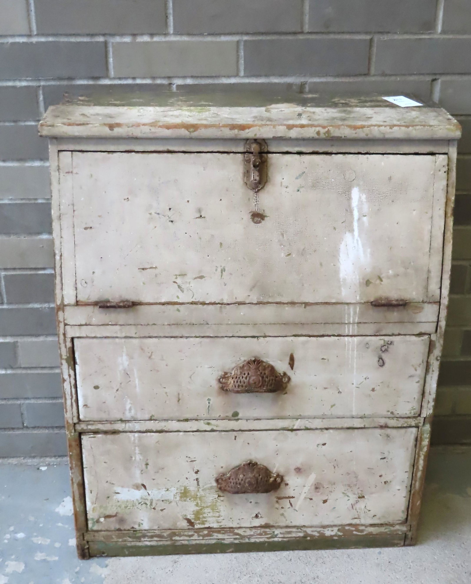 A primitive floor standing desk unit having a drop: A primitive floor standing desk unit having a drop front over 2 drawers with iron pulls in old white over original green paint, circa 1870. The bottom of the rear with losses so does not stand straigh
