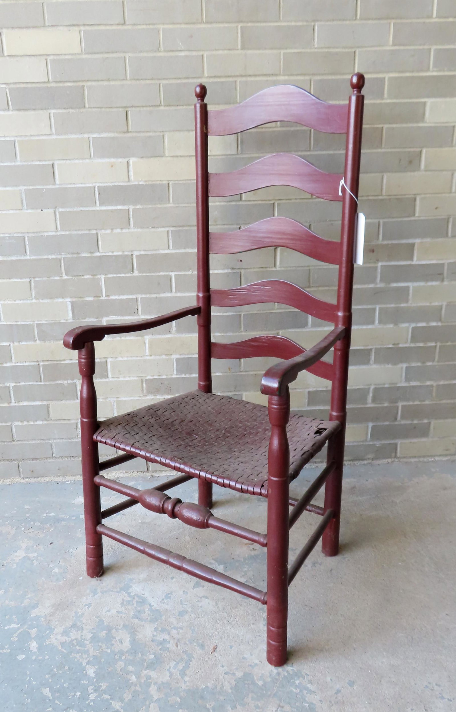 A Delaware Valley arm chair with bulbous cross: A Delaware Valley arm chair with bulbous cross stretcher across the front, original cane seat (needs repair), layers of old paint. All 4 legs have been professionally ended out else good condition. Me