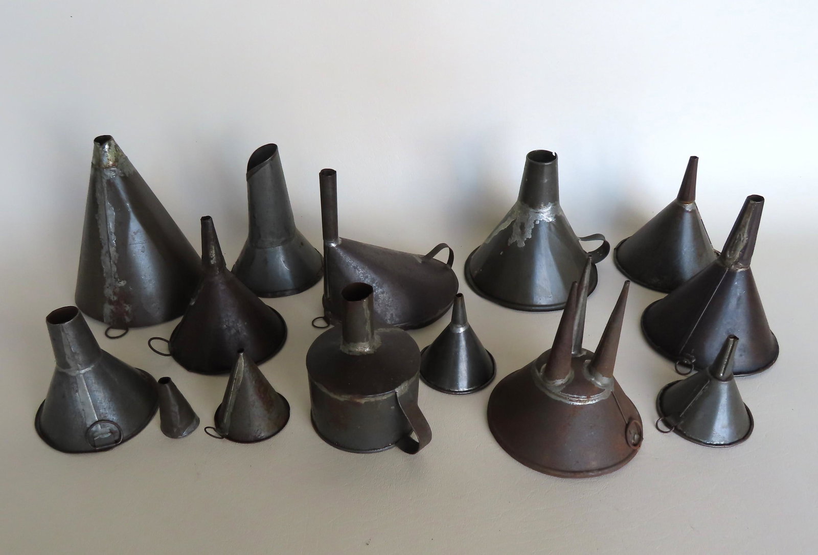 Grouping of tin funnels, late 19th to early 20th c.: Grouping of 14 tin funnels including an unusual 3 hole funnel with finely tapered cones, and one signed W.T. Taliferro - Pat. May 23, 1905 name "INDEX" which has a vertical glass tube on interior that