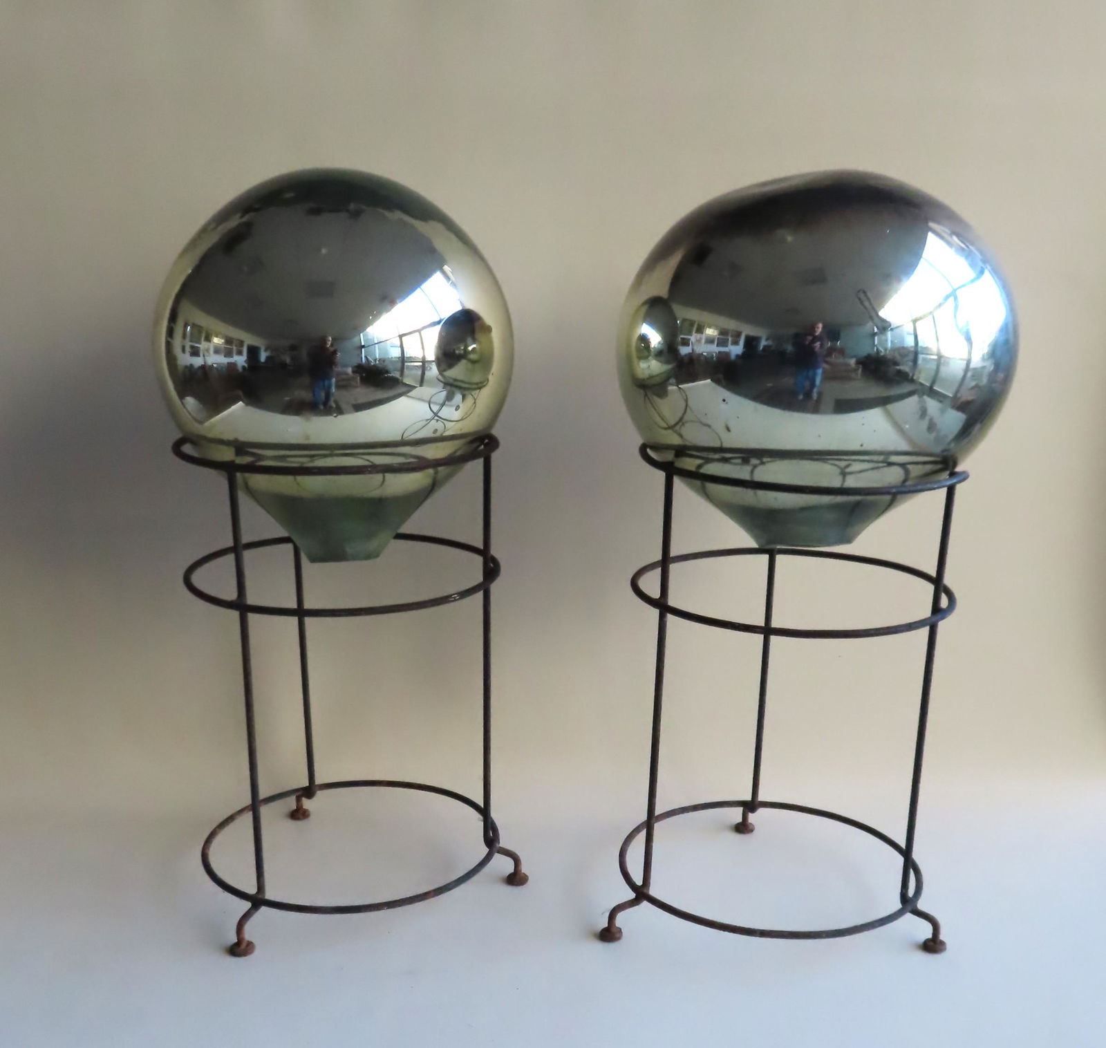 Two mercury glass gazing balls.: Two vintage garden mercury glass gazing balls in silver color. Both with original wire mounting stands. Each ball 11 1/2" diameter x 12"H - the ball on stand measures 24"H. Both in very good condition