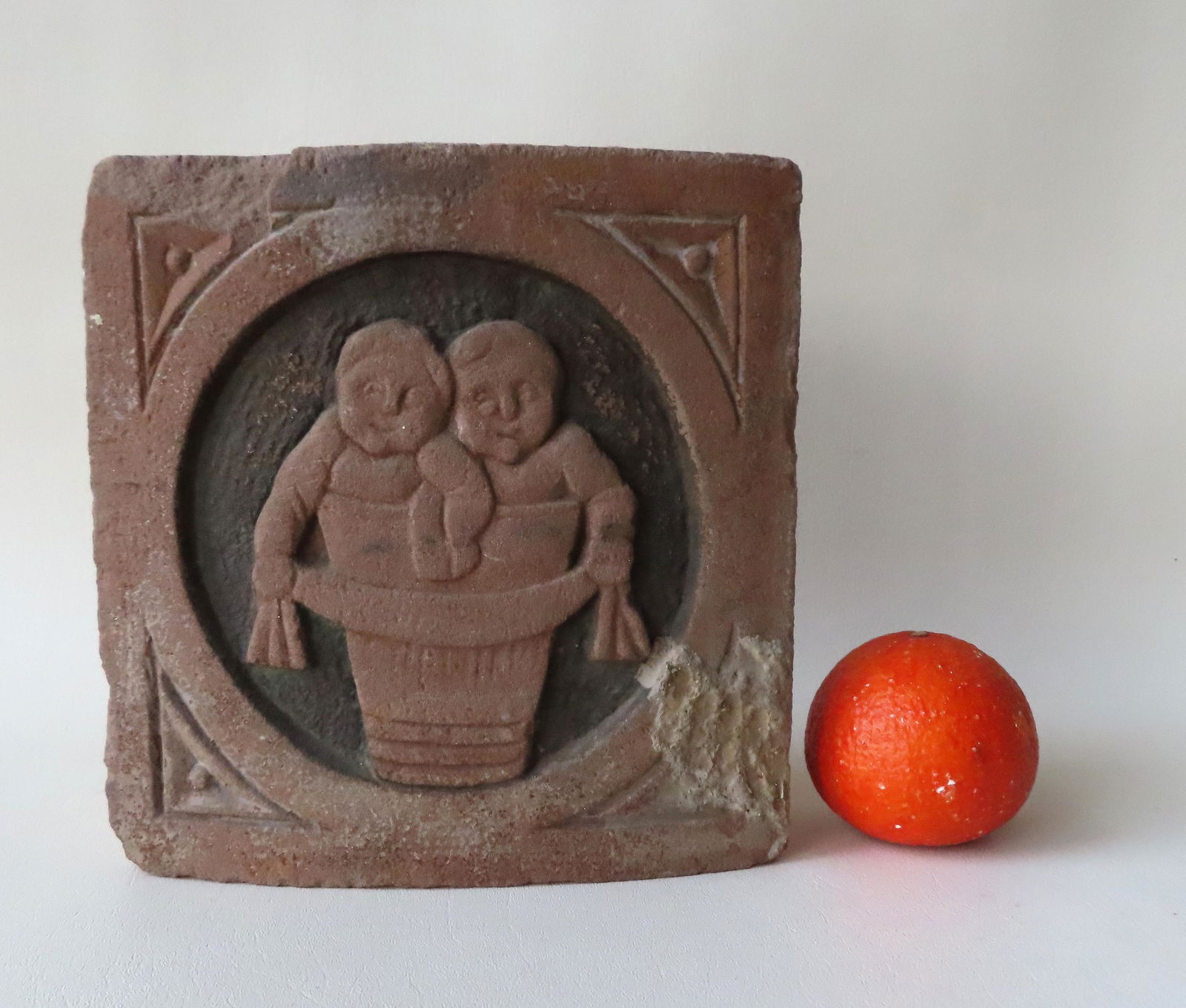 A sandstone block sculpture of twins in a tub or back (1 of 4)