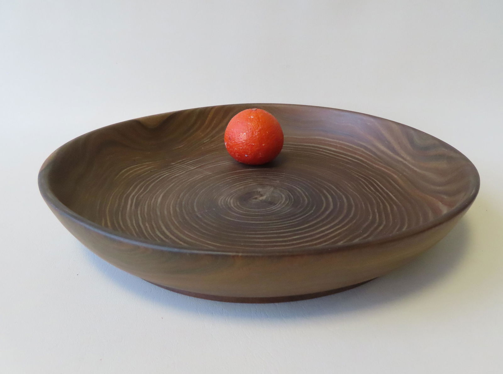 A highly grained mid century style wooden bowl on: A highly grained mid century style wooden bowl on footed base, in exotic wood, circa 1970. Measures 16 1/2" diameter x 3"H.