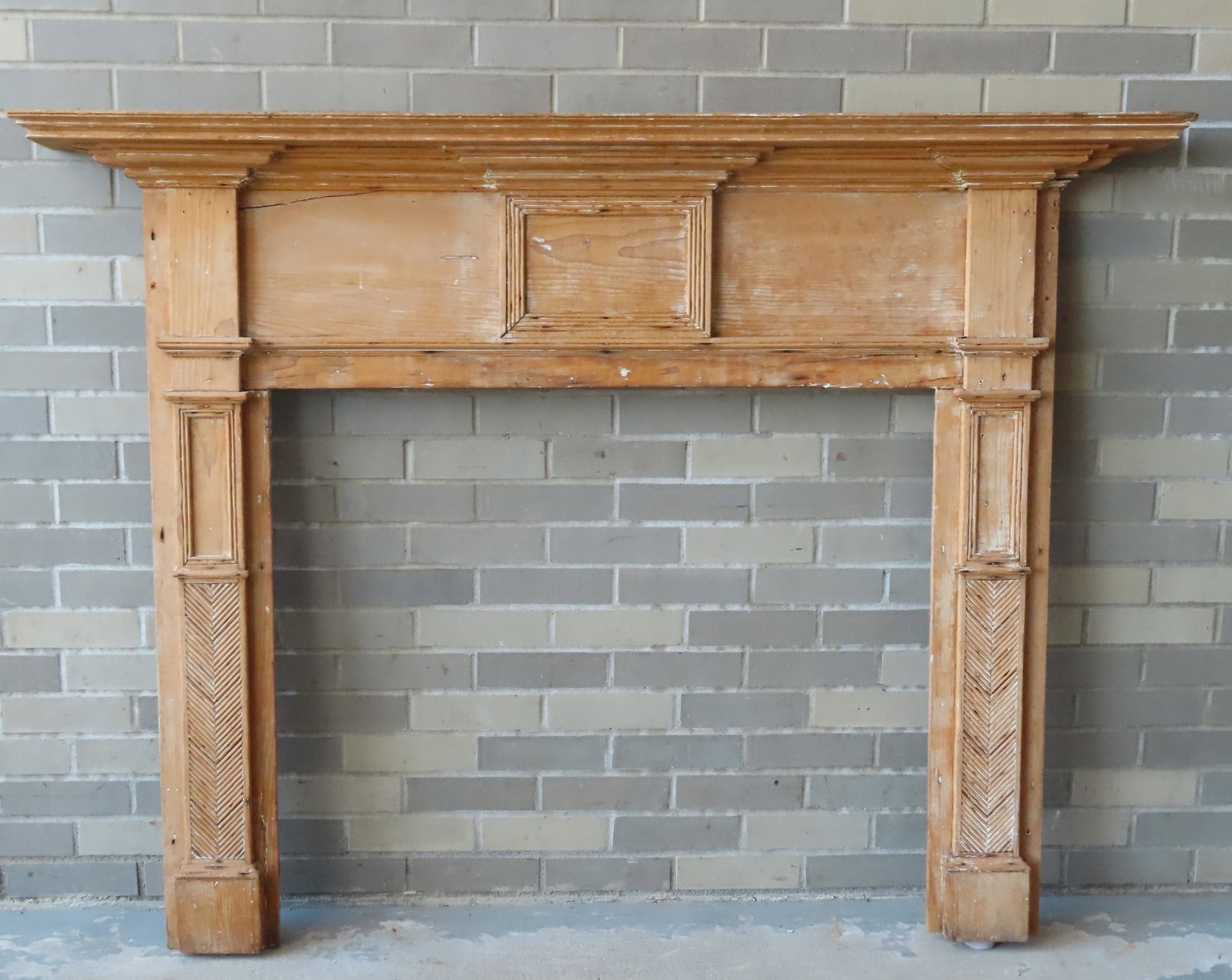 A federal fireplace mantle having an architectural: A federal fireplace mantle having an architectural crown with stepped molding beneath shelf and having herring bone design panels built into the side legs. Mortise and tenon construction. Stripped dow