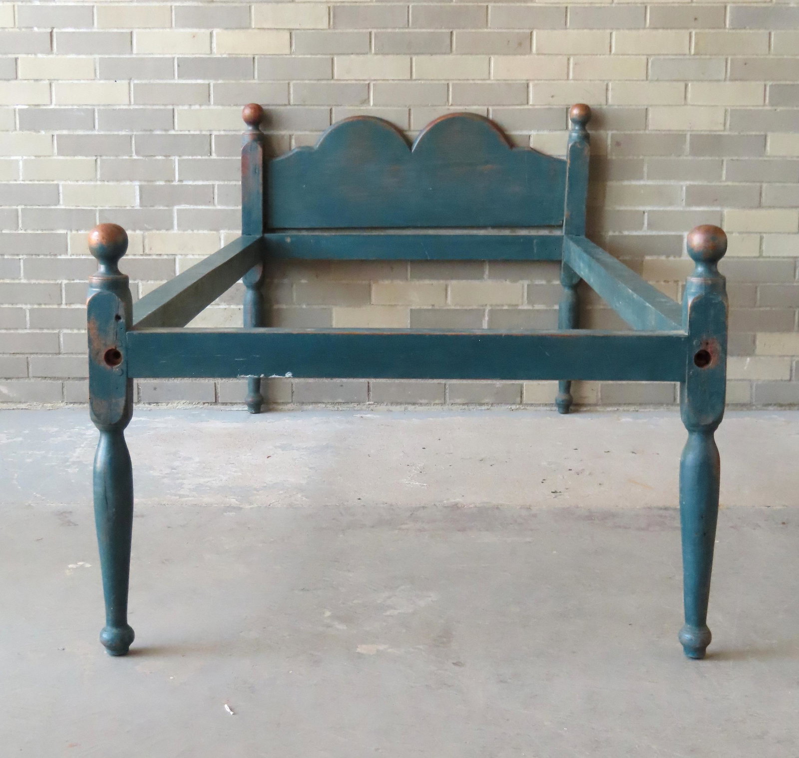 A very fine country birch hired hands bed in original: A very fine country birch hired hands bed in original blue-green paint, probably New England - note the beautiful shaped and chamfered had board and the wear on the small cannon ball finials. Retains 