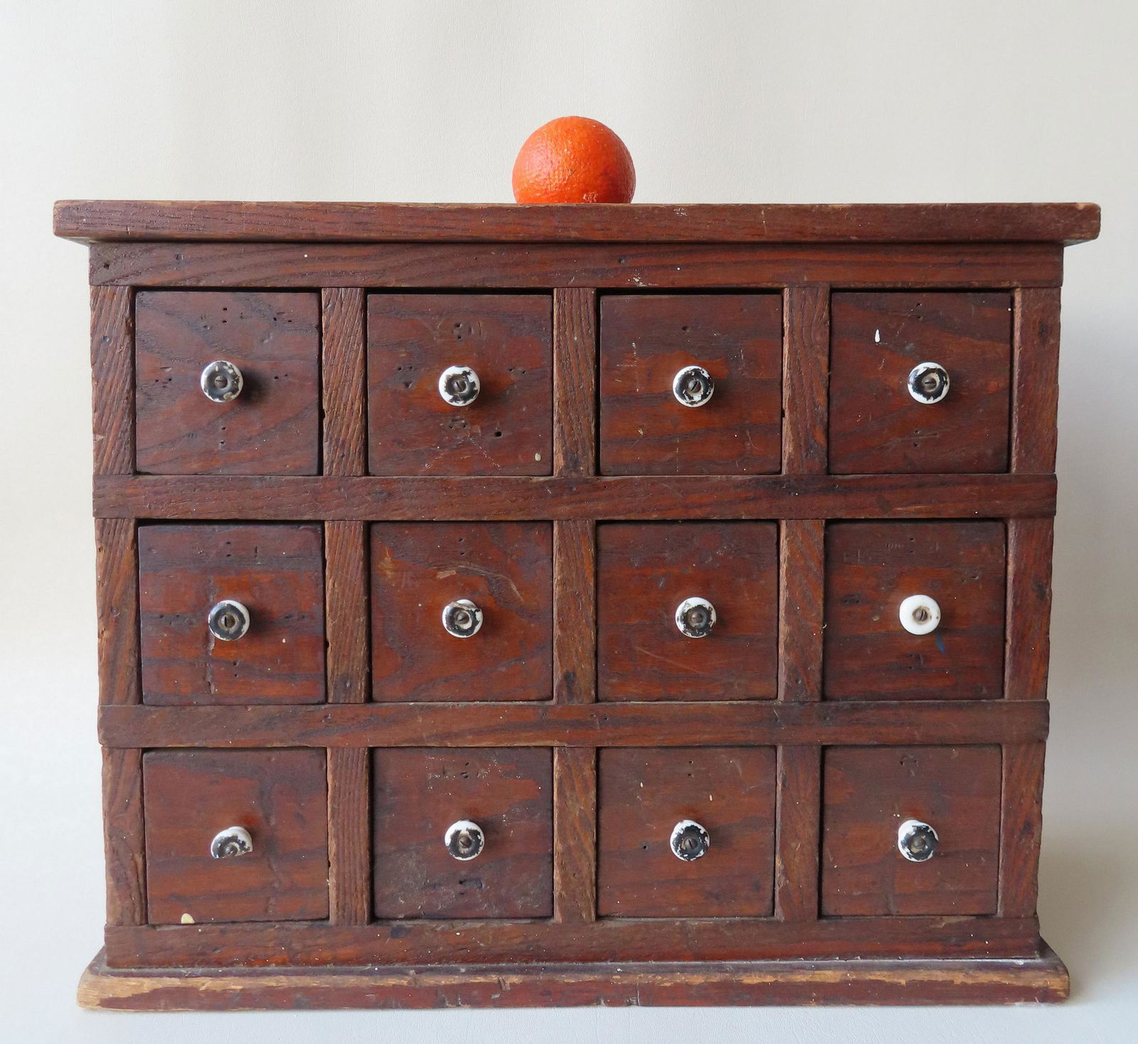 A primitive 12 drawer utility cabinet having 3 rows of (1 of 7)