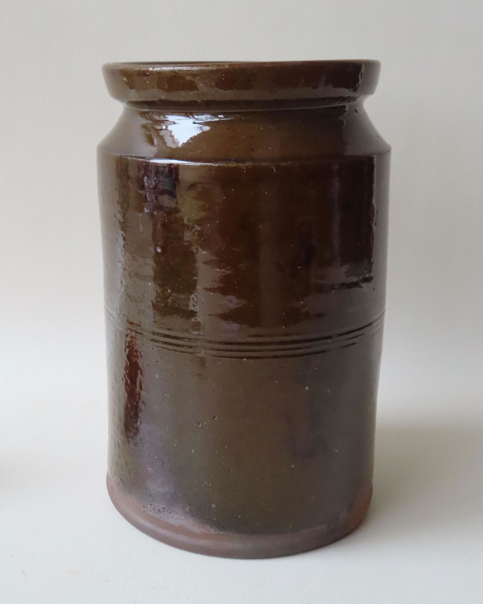 A redware cylindrical jar with several manganese: A redware cylindrical jar with several manganese splotches - 12"H x 7 1/4" dia. - firing imperfection on side where it may have stuck against another jar, otherwise very good condition with no chips,
