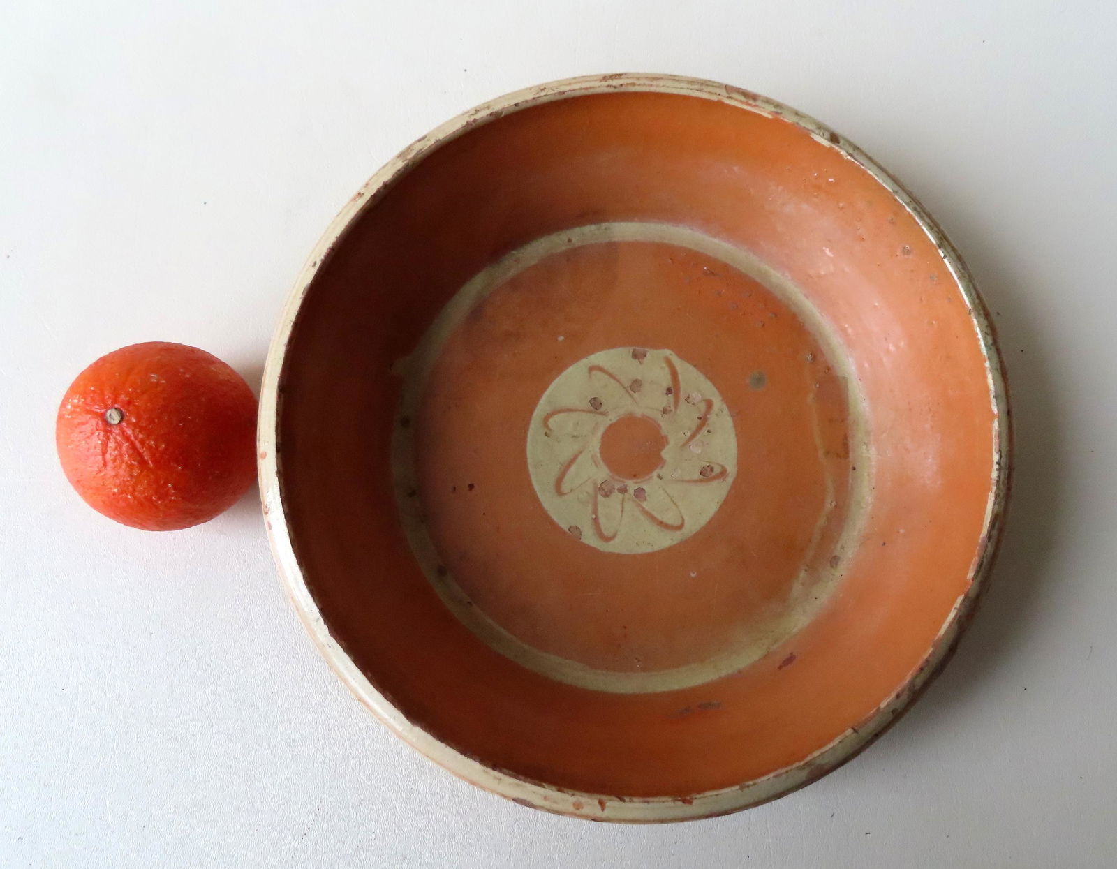 A redware milk pan with a yellow slip flower in the (1 of 4)