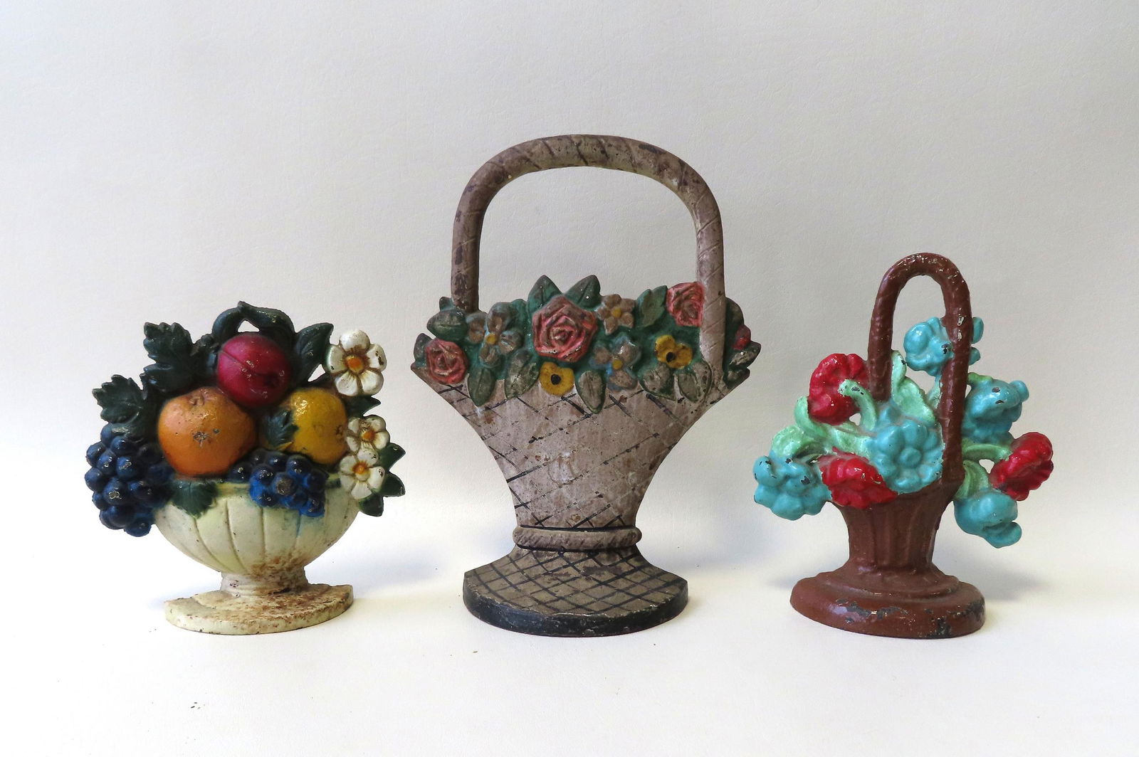 Three colorful cast iron door stops depicting fruit and (1 of 7)
