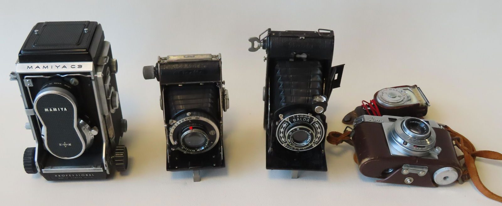 A grouping of 4 cameras and a Sekonic light meter. (1 of 19)