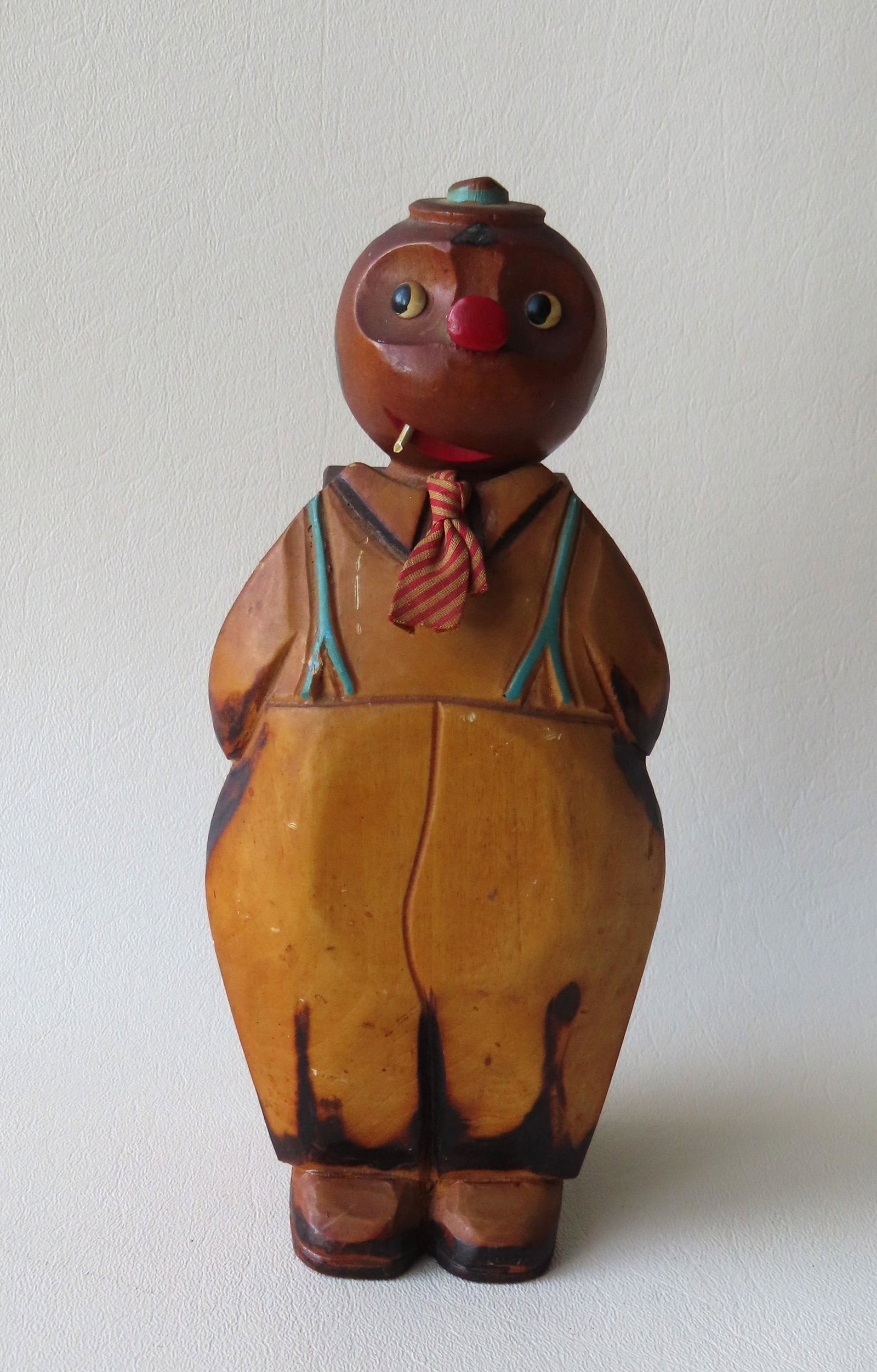 Carved wooden folk art brush and holder in the form of: Carved wooden folk art brush and holder in the form of a whimsical young man wearing hat and smoking a cigarette. Both pieces are in good original paint and very good condition. 8"H x 3 1/2"W.