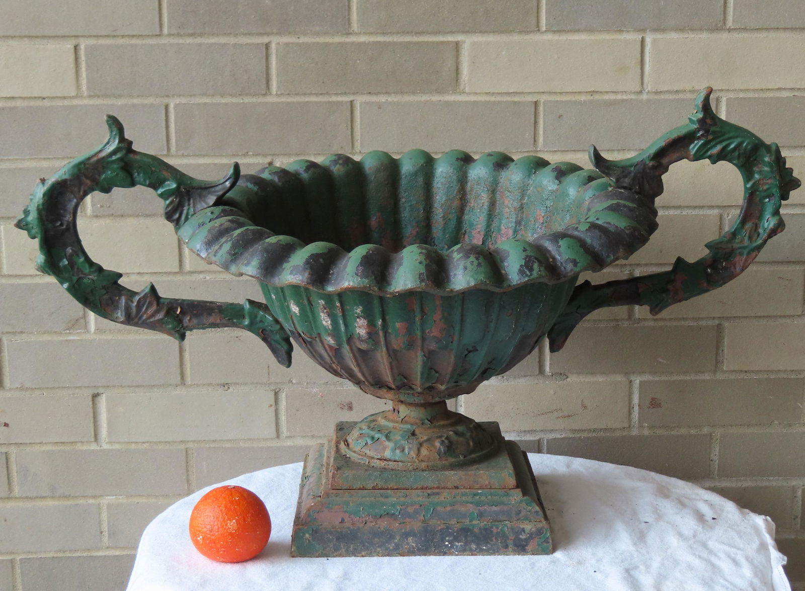A cast iron garden urn mounted on a square and stepped plinth and having scrolled acanthus side (1 of 6)