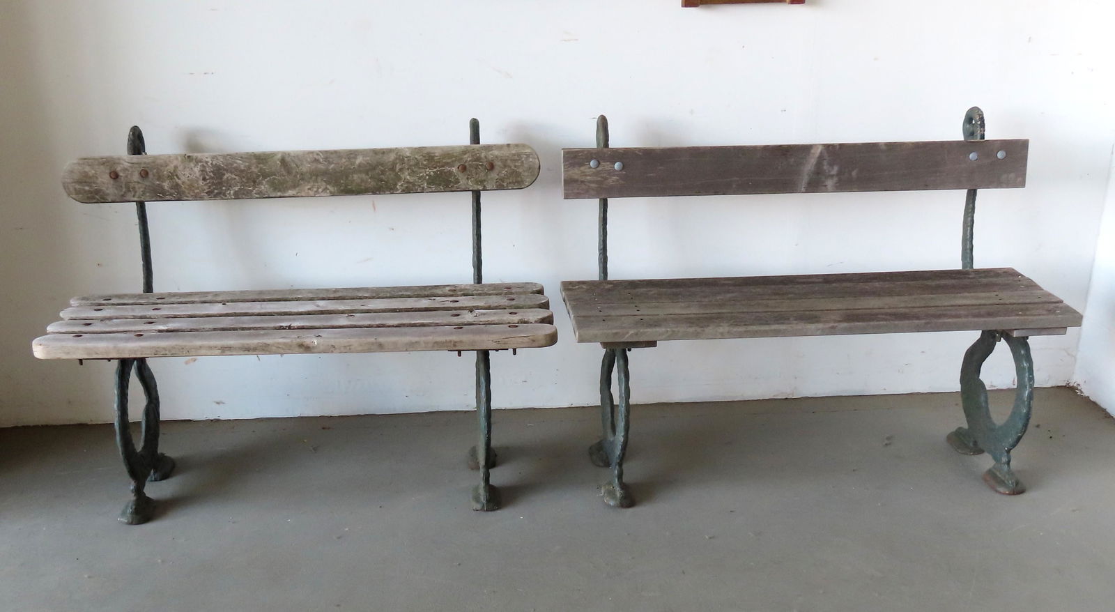 Two matching garden benches with wooden slat seats and backs and having iron sides in the form of an (1 of 12)