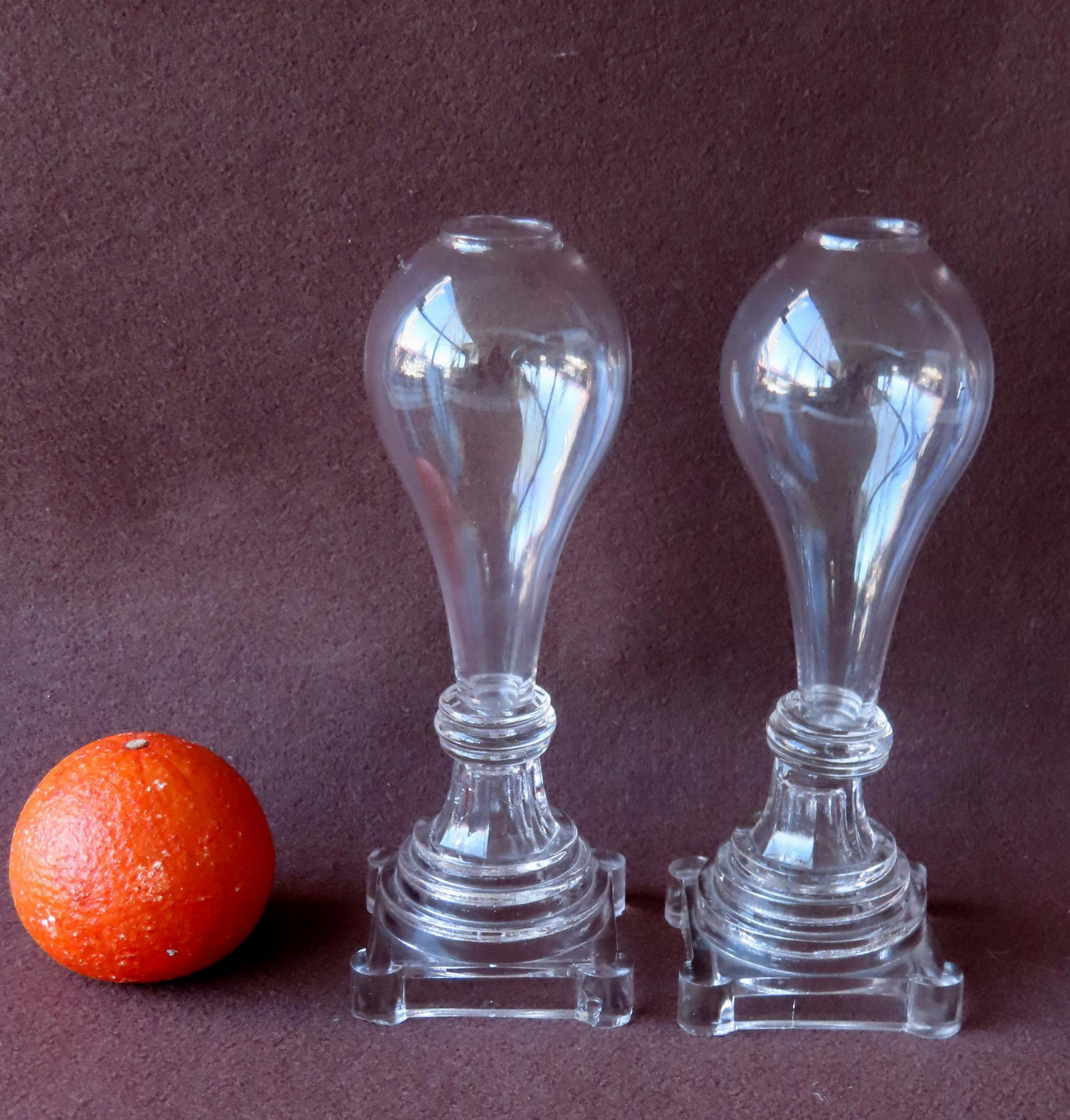 Two matching Sandwich glass whale oil lamps with blown light bulb fonts attached to stepped bases: Two matching Sandwich glass whale oil lamps with blown light bulb fonts attached to stepped bases with 3 layered wafers, 19th century. Both in very good condition. Each measures 8 3/4"H x 3 1/4"W. Pro
