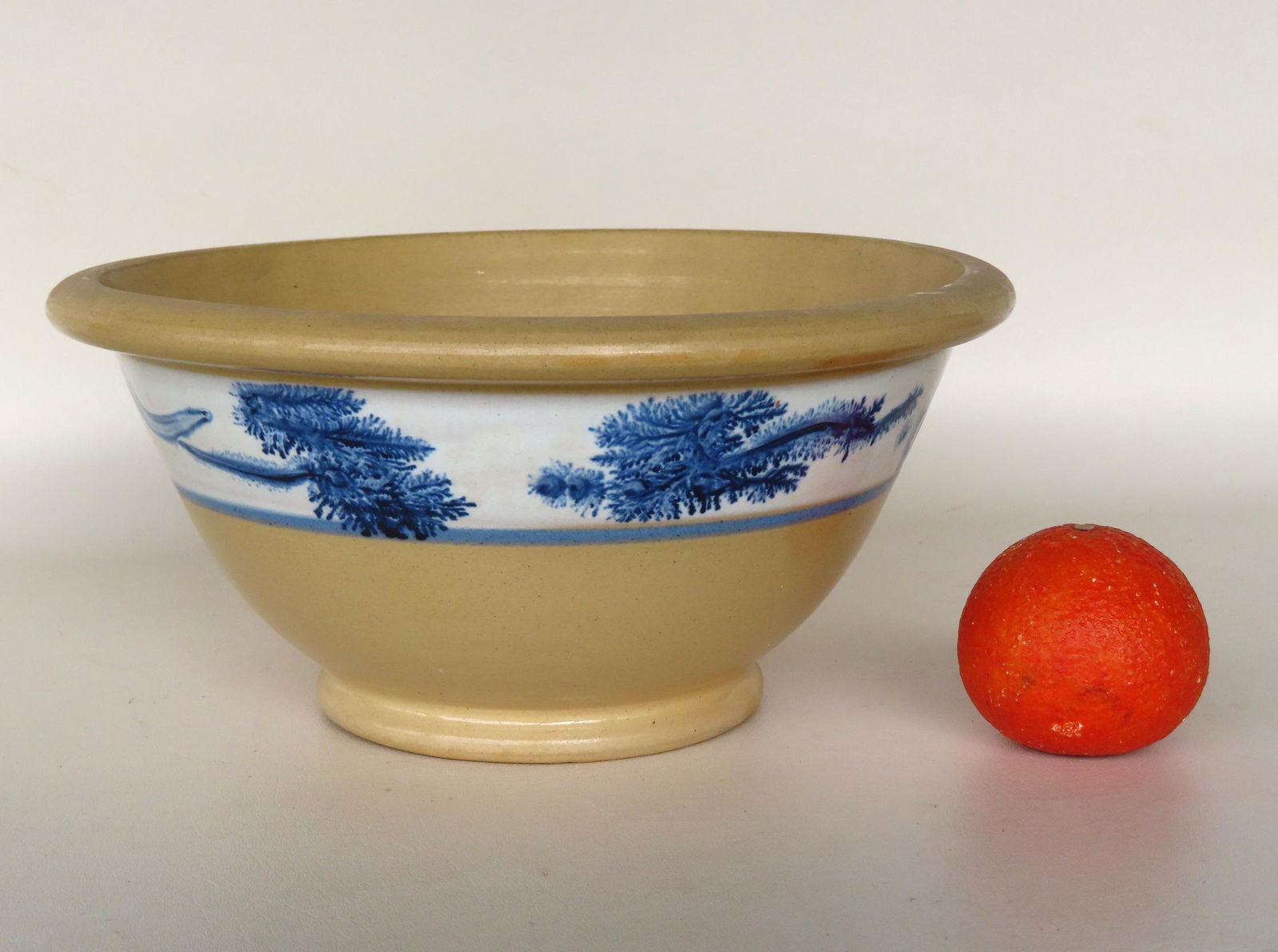 A yellowware mocha bowl with rolled rim, footed base and having seaweed decorations within the white (1 of 5)