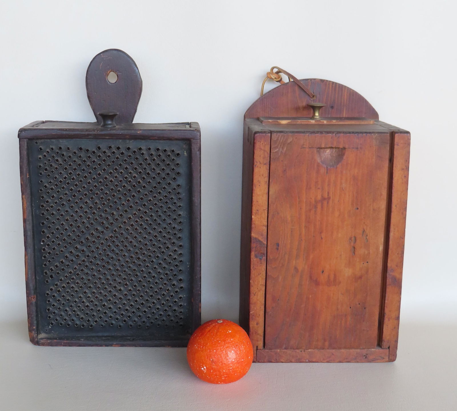 Two primitive home made wood and tin cheese graters with drawer. Both Mid to late 19th century. One: Two primitive home made wood and tin cheese graters with drawer. Both Mid to late 19th century. One with lollipop handle in original black stain with grater mounted to the front - 15"L x 8 3/4"W x 3 3