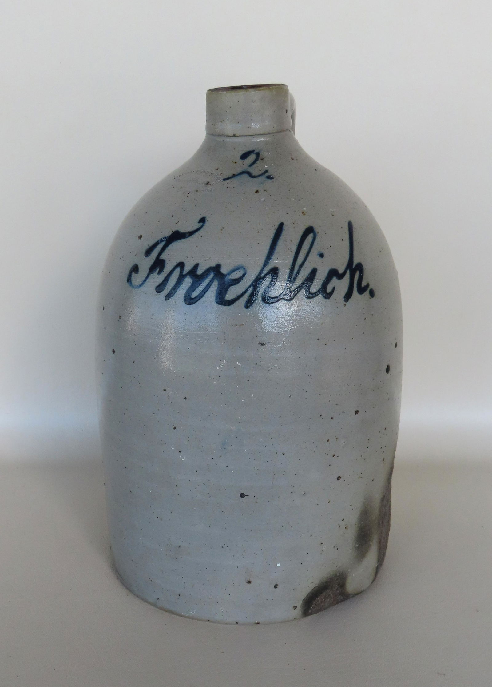 A stoneware script jug, 2 gallon,  signed "Froehlich" and marked with a cobalt blue "2", having an (1 of 5)