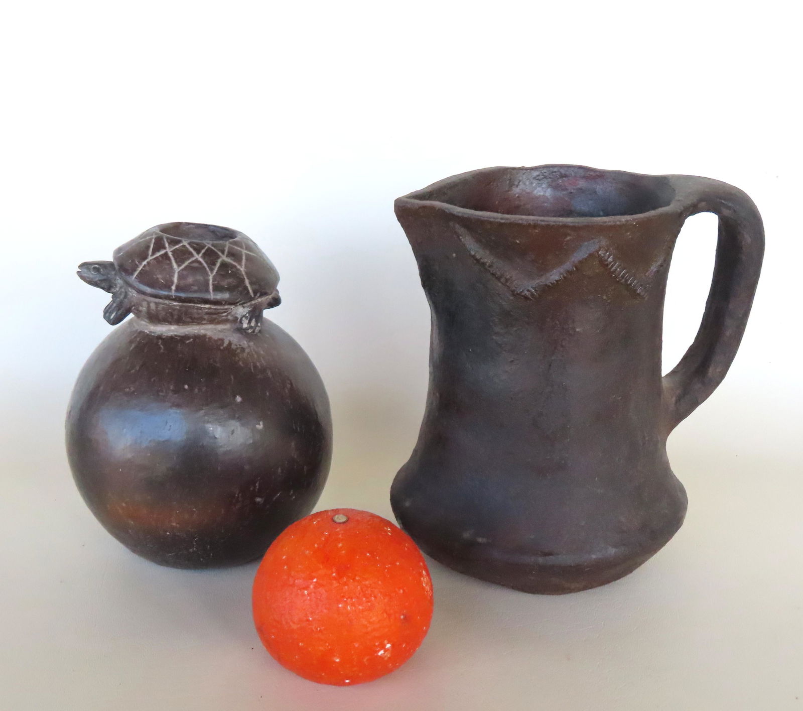 Two Native American pottery collectibles including: A Navajo water pitcher, redware clay, with note (1 of 11)