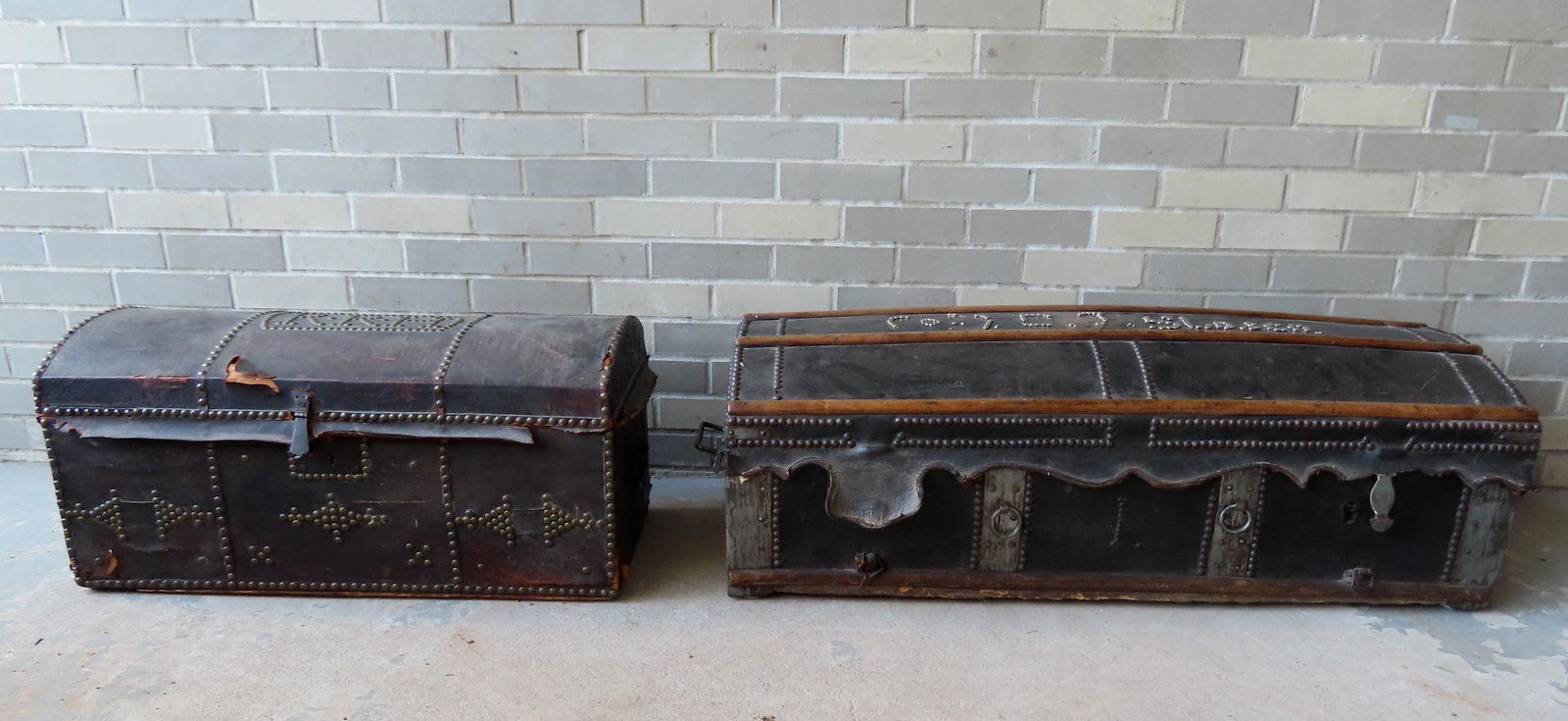 Two early dome top leather trunks. The first decorated with oak straps and tacks and iron bail (1 of 19)