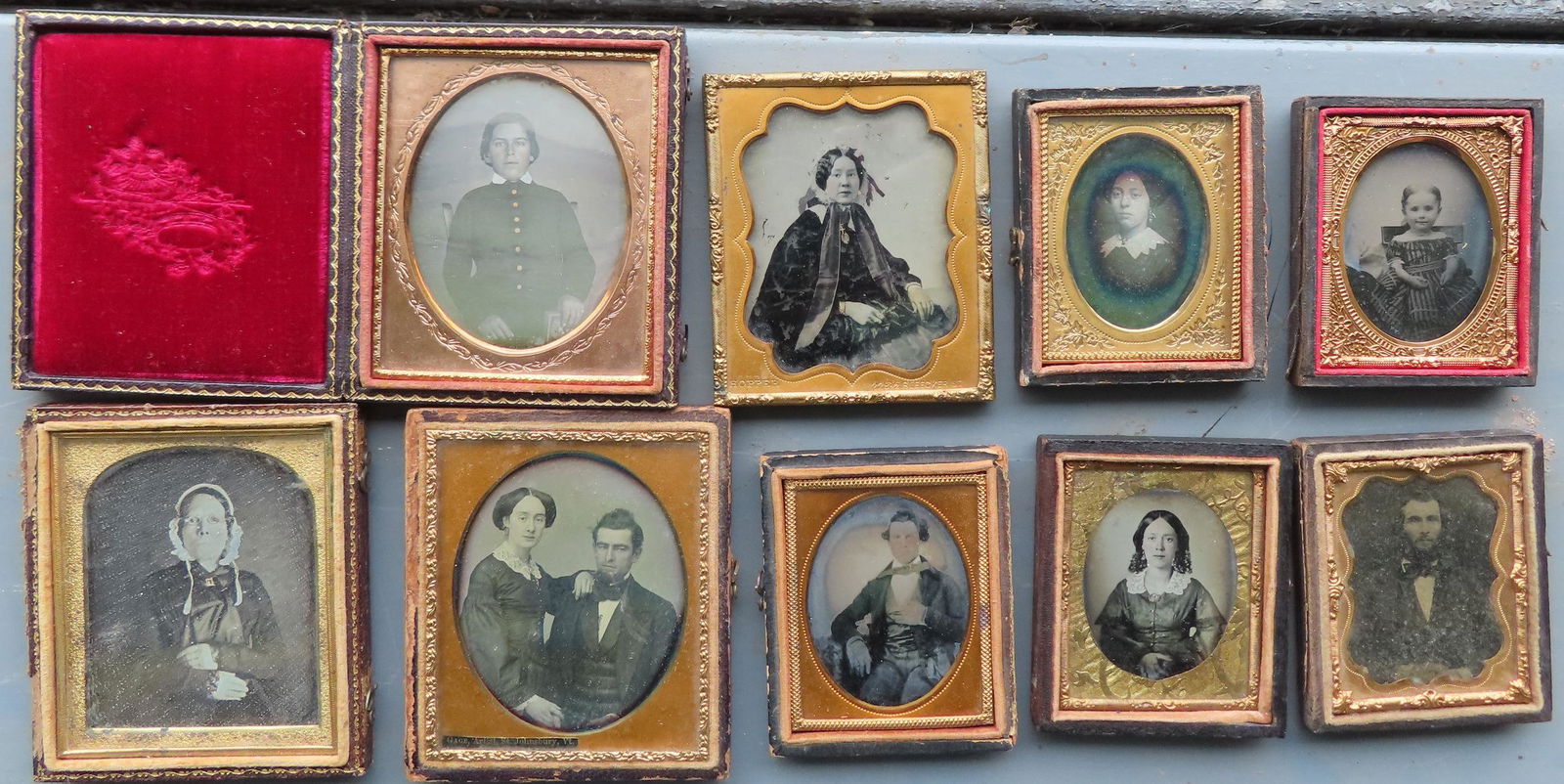 A grouping of 9 cased photos including: Four daguerreotypes including lady wearing glasses, man and (1 of 7)