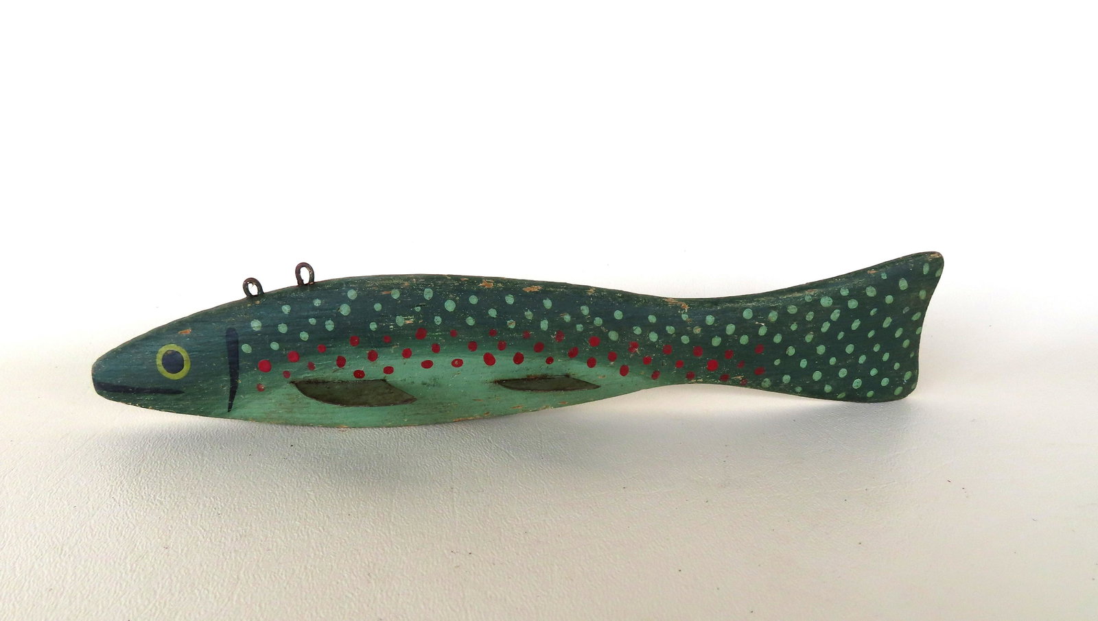 Carved wooden ice fishing decoy in original paint likely to simulate a trout, having 4 tin fins,: Carved wooden ice fishing decoy in original paint likely to simulate a trout, having 4 tin fins, double lead weights added to underside of body, and curved tail. Circa 1960-70, very good condition. Me