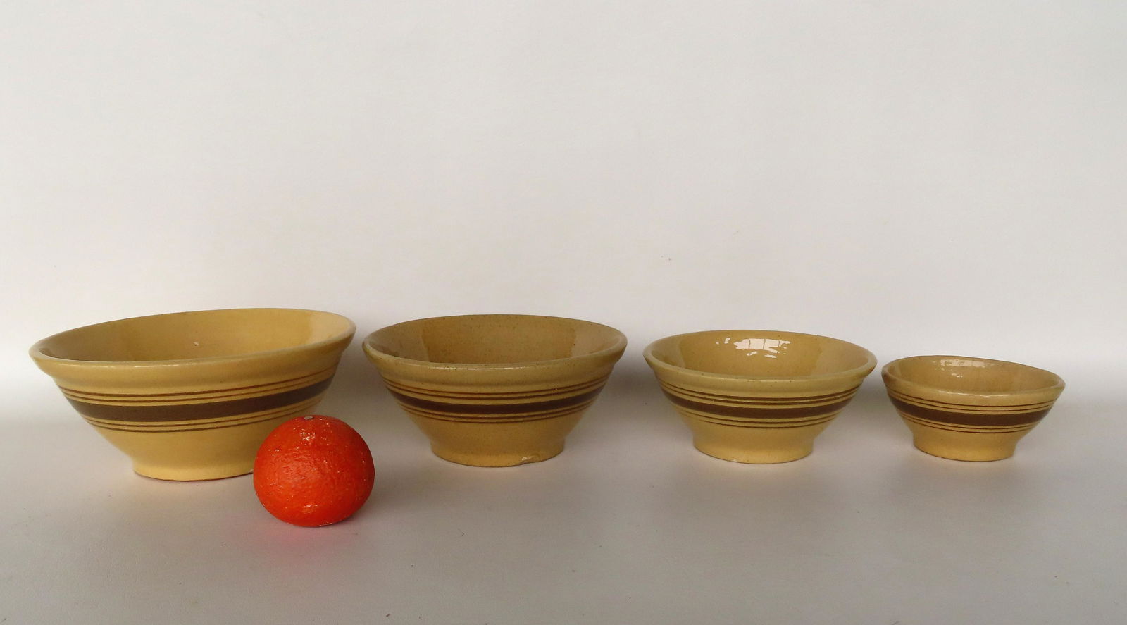 A nested set of  yellowware mixing bowls with brown bands, ranging in size from 5  1/2" diameter x 2 (1 of 6)